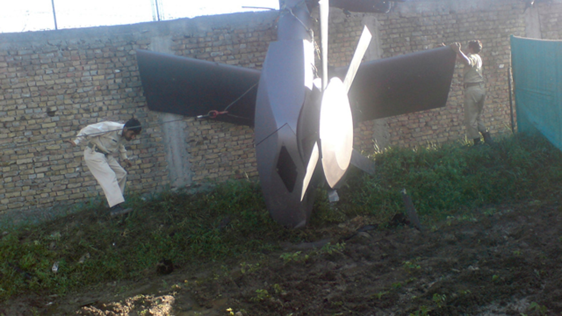 Part of a damaged helicopter is seen lying near the compound after U.S. Navy SEAL commandos killed al Qaeda leader Osama bin Laden in Abbottabad, May 2, 2011. Bin Laden was killed in the U.S. special forces assault on the Pakistani compound, then quickly buried at sea, in a dramatic end to the long manhunt for the al Qaeda leader who had been the guiding star of global terrorism. Picture taken May 2, 2011. REUTERS/Stringer (PAKISTAN - Tags: CRIME LAW POLITICS CIVIL UNREST IMAGES OF THE DAY)