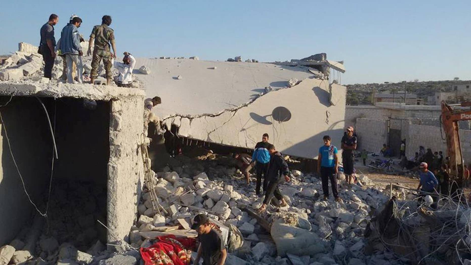 FILE - In this Tuesday Sept. 23, 2014 file photo provided by an anti-Bashar Assad activist group Edlib News Network (ENN), which has been authenticated based on its contents and other AP reporting, Syrian citizens check a damaged house that they say was targeted by the coalition airstrikes in the village of Kfar Derian, a base for the al-Qaida-linked Nusra Front, a rival of the Islamic State group, between the northern province of Aleppo and Idlib, Syria. U.S.-led coalition airstrikes against the Islamic State group and other extremists in Syria have killed more than 860 people, including civilians, since they began in mid-September, a monitoring group said Wednesday, Nov. 12. (AP Photo/Edlib News Network ENN, File)