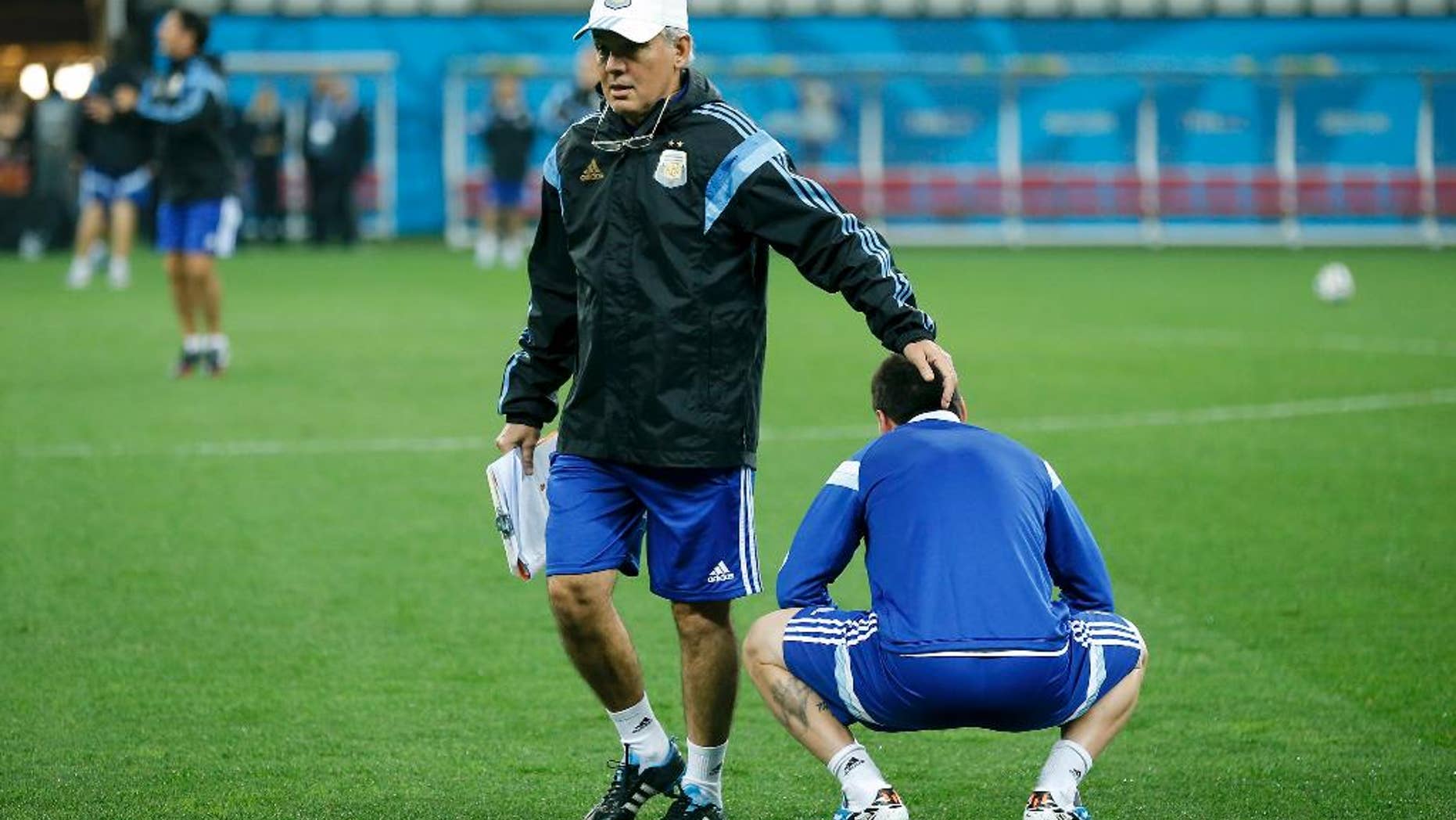 Argentina's head coach Alejandro Sabella touches the head of Argentina's Lionel Messi during a training session one day before their World Cup semifinal soccer match against Netherlands at Itaquerao Stadium in Sao Paulo, Brazil, Tuesday, July 8, 2014. (AP Photo/Victor R. Caivano)