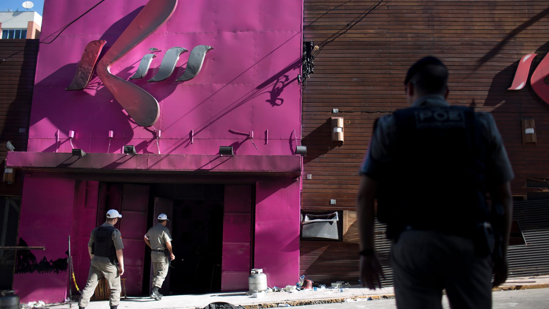 FILE - In this Jan. 28, 2013, file photo, police officers enter the Kiss nightclub after a fatal fire in Santa Maria city, Rio Grande do Sul state, Brazil. Just over a week since the nightclub fire killed nearly 240 revelers in southern Brazil, Carnival festivities hit full stride Friday, Feb. 8, raising questions about the safety of those who will pack party spaces across the nation. (AP Photo/Felipe Dana, file)