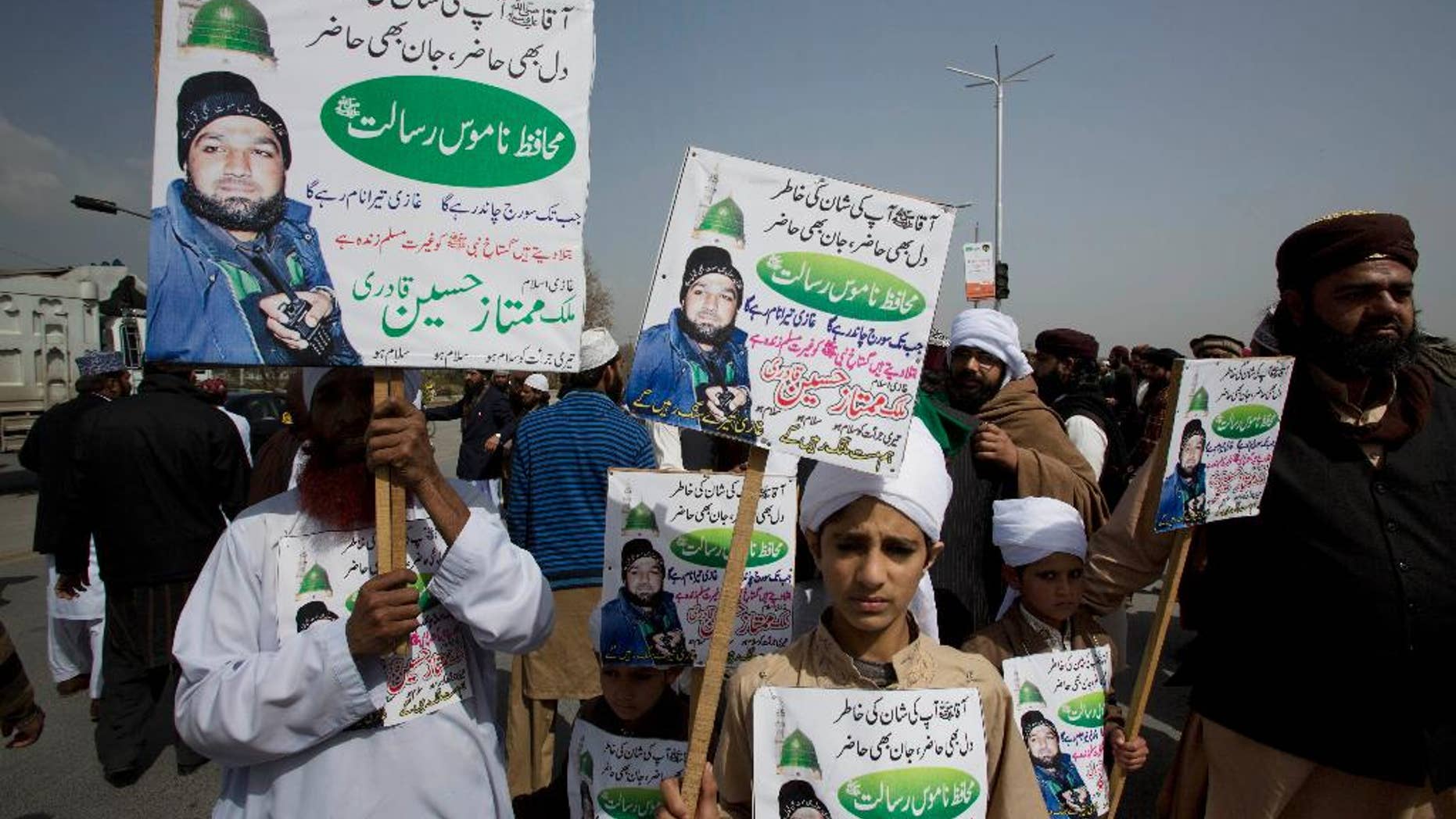 Supporters of Pakistan's Mumtaz Qadri, a former police commando who killed Punjab's governor Salman Taseer, block a highway to protest against a court decision in Islamabad, Pakistan, Monday, March 9, 2015. A Pakistani court has upheld the death sentence of a man convicted of killing a provincial governor he had accused of blasphemy. Placards read "Prophet we are ready to render our lives for your sanctity." (AP Photo/B.K. Bangash)