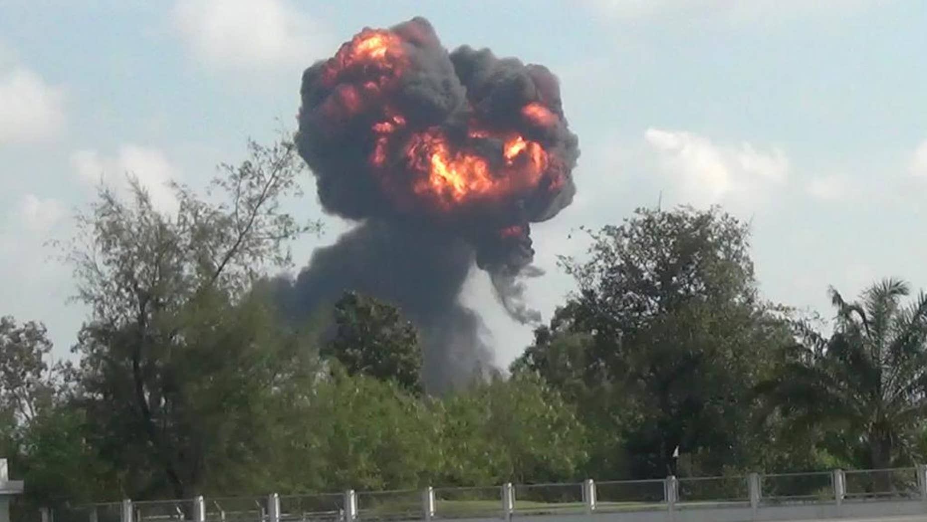 In this image made from video, a plume of smoke and fire rises from the site where a fighter jet crashed during and airshow, Saturday, Jan. 4, 2017, in Hat Yai, southern Thailand. A Thai air force pilot died when the JAS Gripen fighter jet crashed during an air show celebrating the country's Children's Day. (AP Photo)
