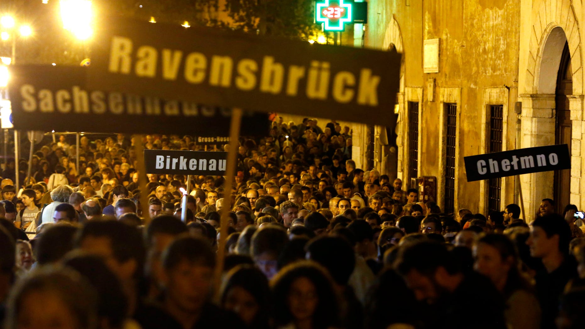 People hold up signs with names of Nazi concentration and death camps during a march marking the 70th anniversary of the roundup and deportation of Rome's Jews to concentration camps, in Rome's ghetto neighborhood, Wednesday, Oct. 16, 2013. Nazi forces rounded up more than 1,000 Jews from Rome's ghetto and nearby neighborhoods and sent them by train to Auschwitz. Only 16 survived. Rome's Jewish community, which gathered Wednesday amid deep anger over the late Nazi war criminal Erich Priebke and his Holocaust-denying final statement. Priebke died Friday in Rome, where he was serving a life term for his role in the 1944 massacre of 335 civilians at the Ardeatine Caves outside the capital. (AP Photo/Riccardo De Luca)