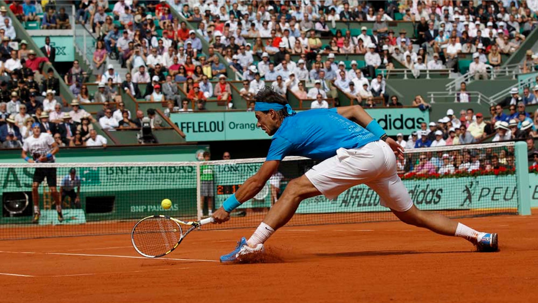 Defending champion Spain's Rafael Nadal returns the ball to USA's John Isner during their first round match of the French Open tennis tournament, at the Roland Garros stadium in Paris, Tuesday, May 24, 2011. (AP Photo/Christophe Ena)