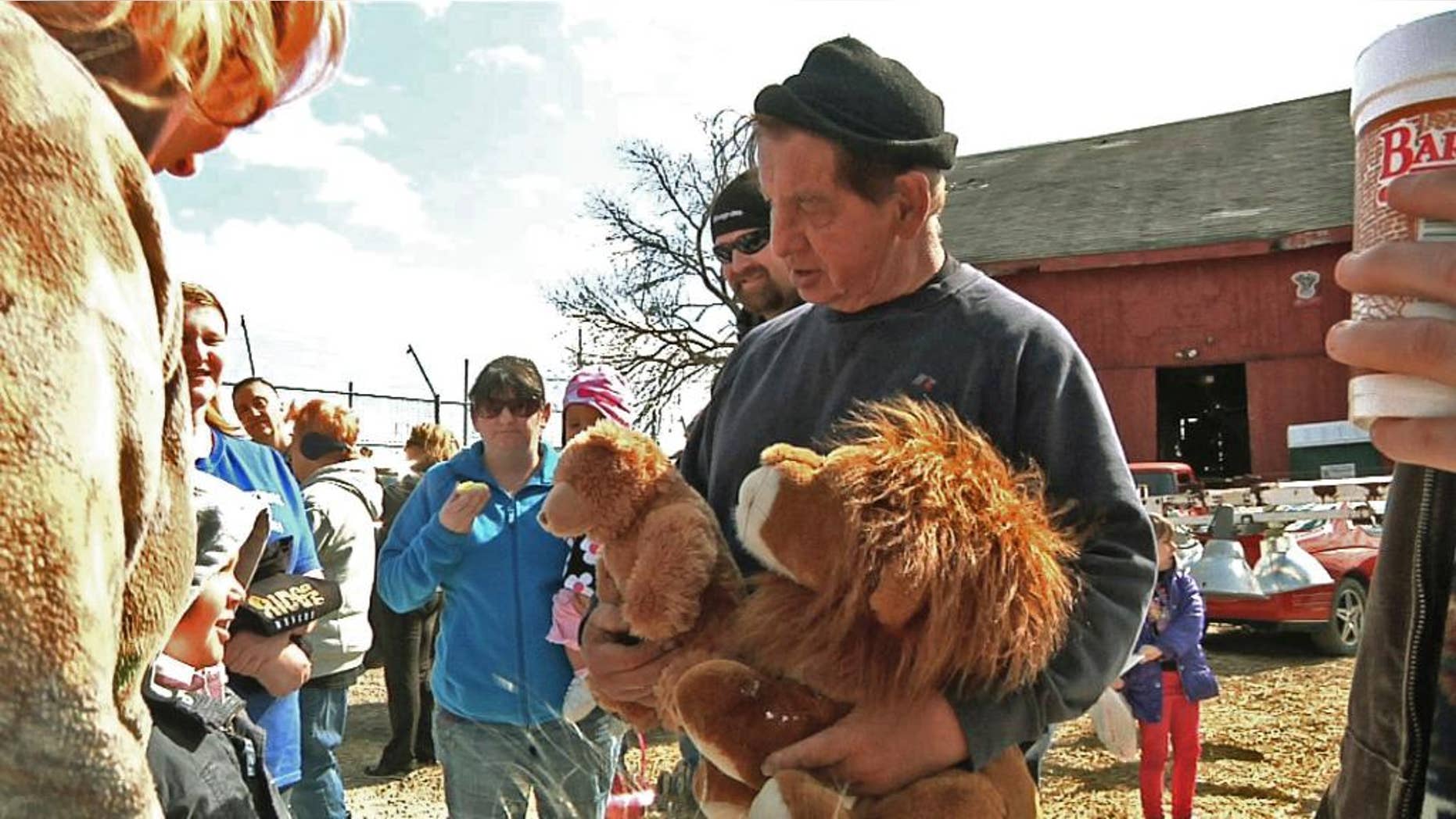 FILE – In this April 4, 2015, file photo, Kenny Hetrick, owner of Tiger Ridge Exotics, holds stuffed toy animals as he speaks to visitors at an Easter egg hunt fundraiser in Stony Ridge, Ohio. Hetrick, who is fighting the state for the return of his tigers and other exotic animals, will be allowed to see some of the animals. A state appeals court said the owner and his veterinarian will be allowed to examine the animals that were sent to a South Dakota sanctuary and later removed from there because of neglect. (AP Photo/Mike Householder, File)