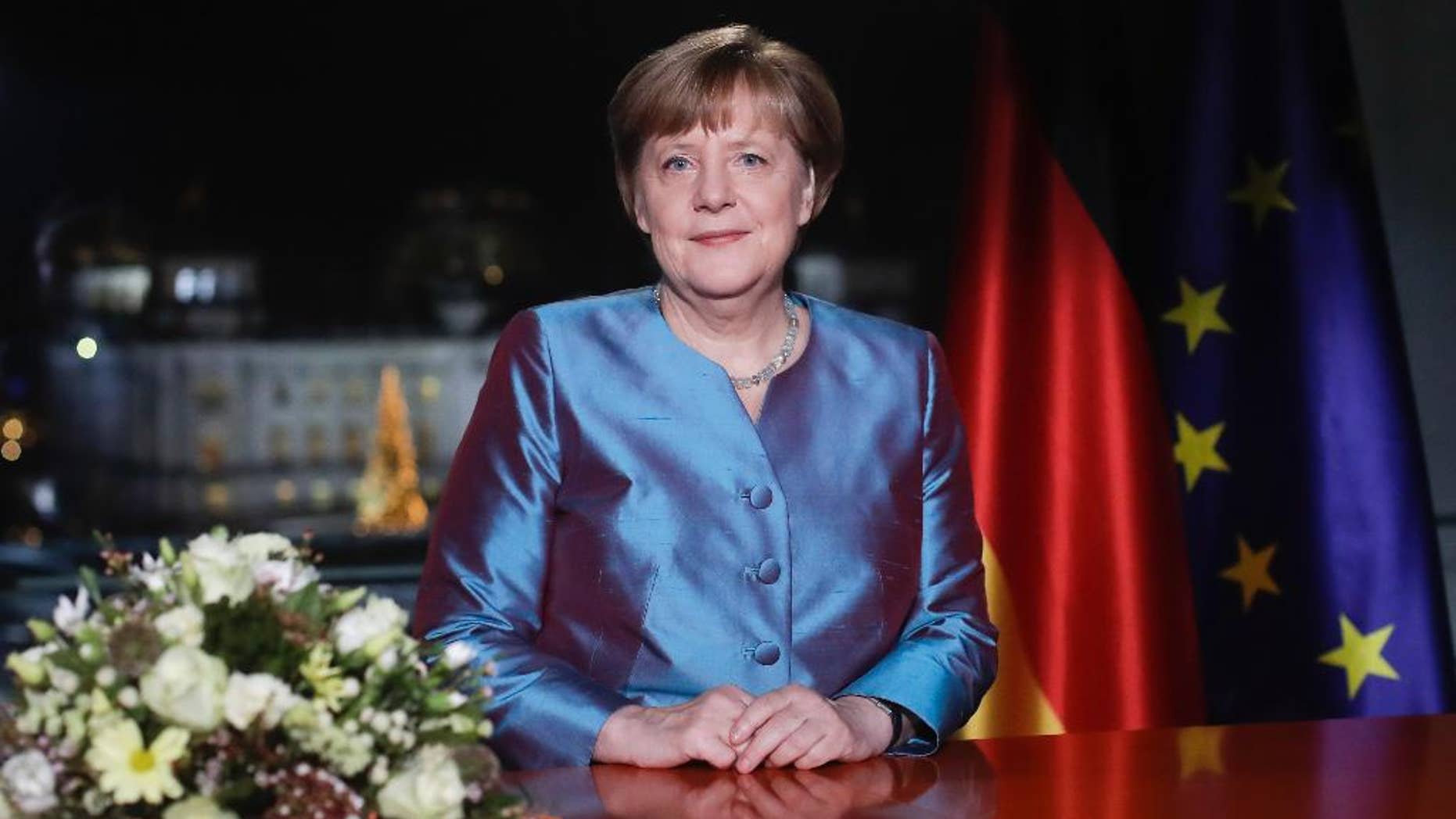 German Chancellor Angela Merkel poses for photographs after the television recording of her annual New Year's speech at the chancellery in Berlin, Friday, Dec. 30, 2016, (AP Photo/Markus Schreiber, Pool)