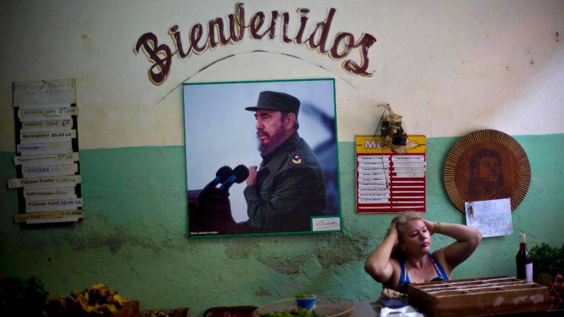 FILE - In this Dec. 26, 2014 file photo, a photograph of Fidel Castro hangs under the Spanish word "Welcome" on the wall at a state-run food market in Havana, Cuba. On Monday, Jan. 26, 2015, after more than a month of silence, Castro made his first public comments about the news that the U.S. and his island nation will restore diplomatic relations after more than 50 years of hostility. (AP Photo/Ramon Espinosa, File)