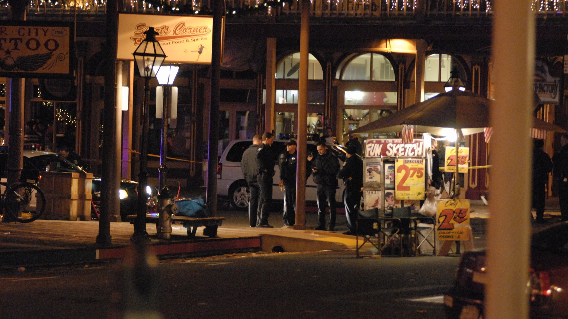 In this image provided by Robert Petersen police inspect the scene of a shooting outside the Sports Corner Cafe in Sacramento Calif. Monday Dec. 31, 2012. Police say two people died and three others were injured in a New Year's Eve shooting after a fight in a restaurant in the Old Sacramento area. After the shooting, police decided to cancel the area's midnight fireworks show, which were part of the New Year's Eve celebration. (AP Photo/Robert Petersen)