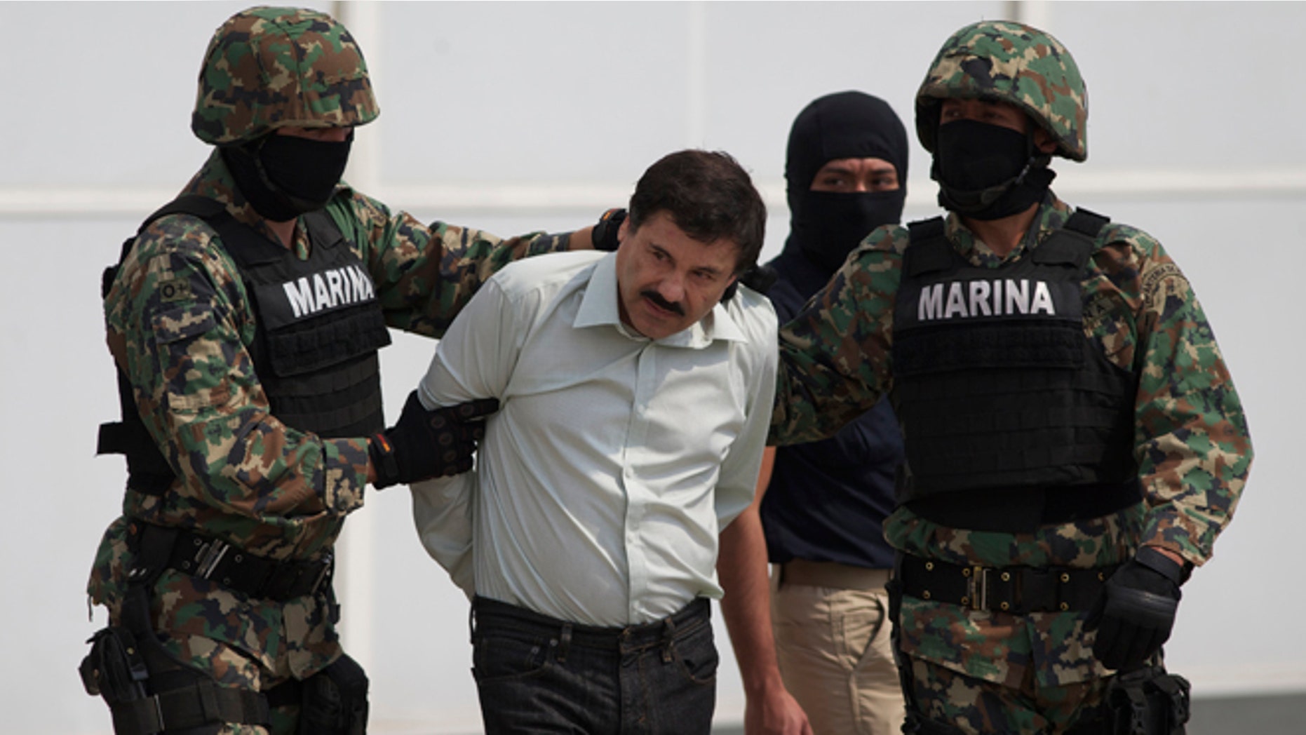 Joaquin "El Chapo" Guzman is escorted to a helicopter in Mexico City, Saturday, Feb. 22, 2014.