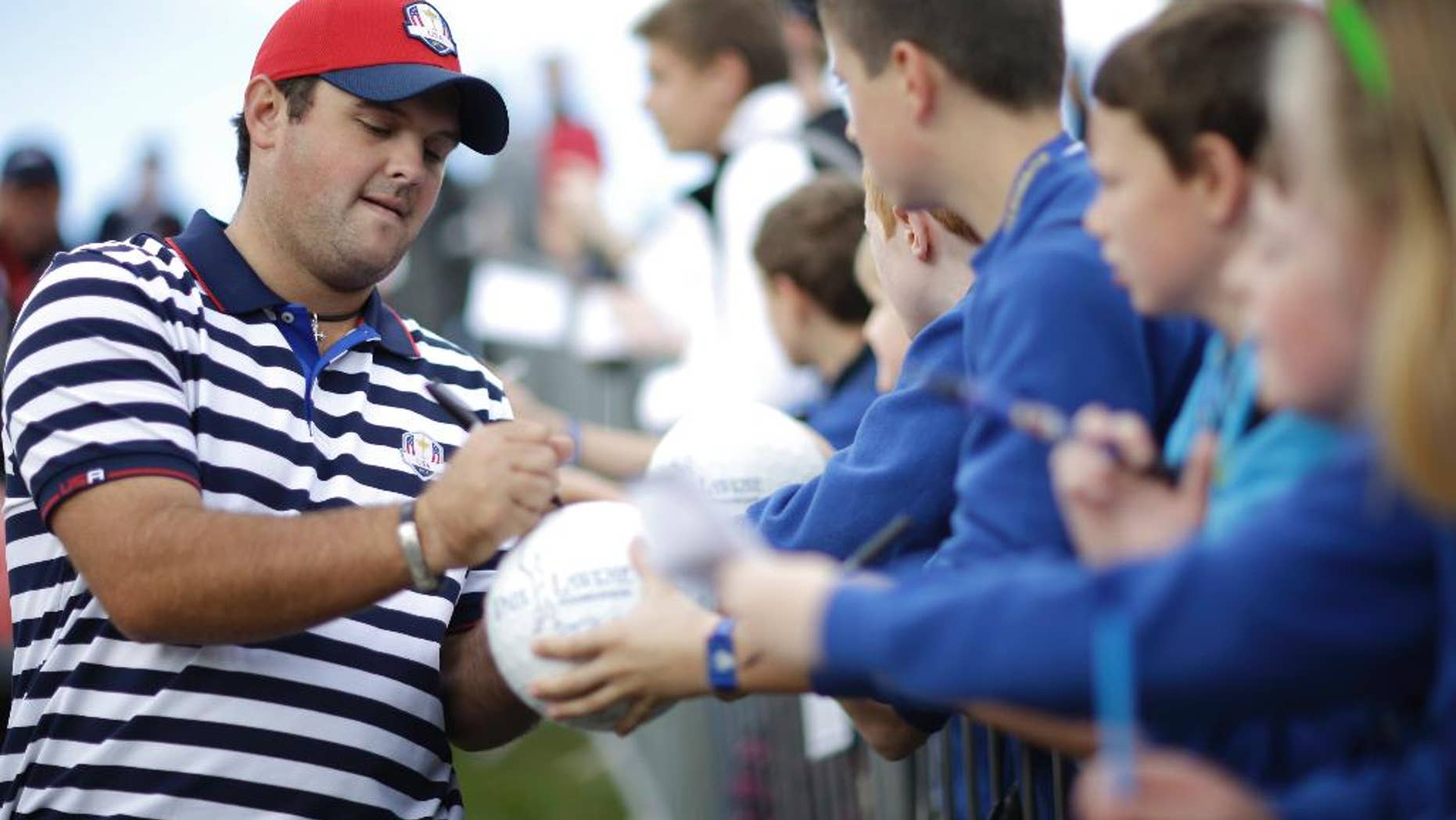 Patrick Reed of the US signs autographs for fans on his way to the 9th tee box during a practice round ahead of the Ryder Cup golf tournament, at Gleneagles, Scotland, Wednesday, Sept. 24, 2014. (AP Photo/Matt Dunham)