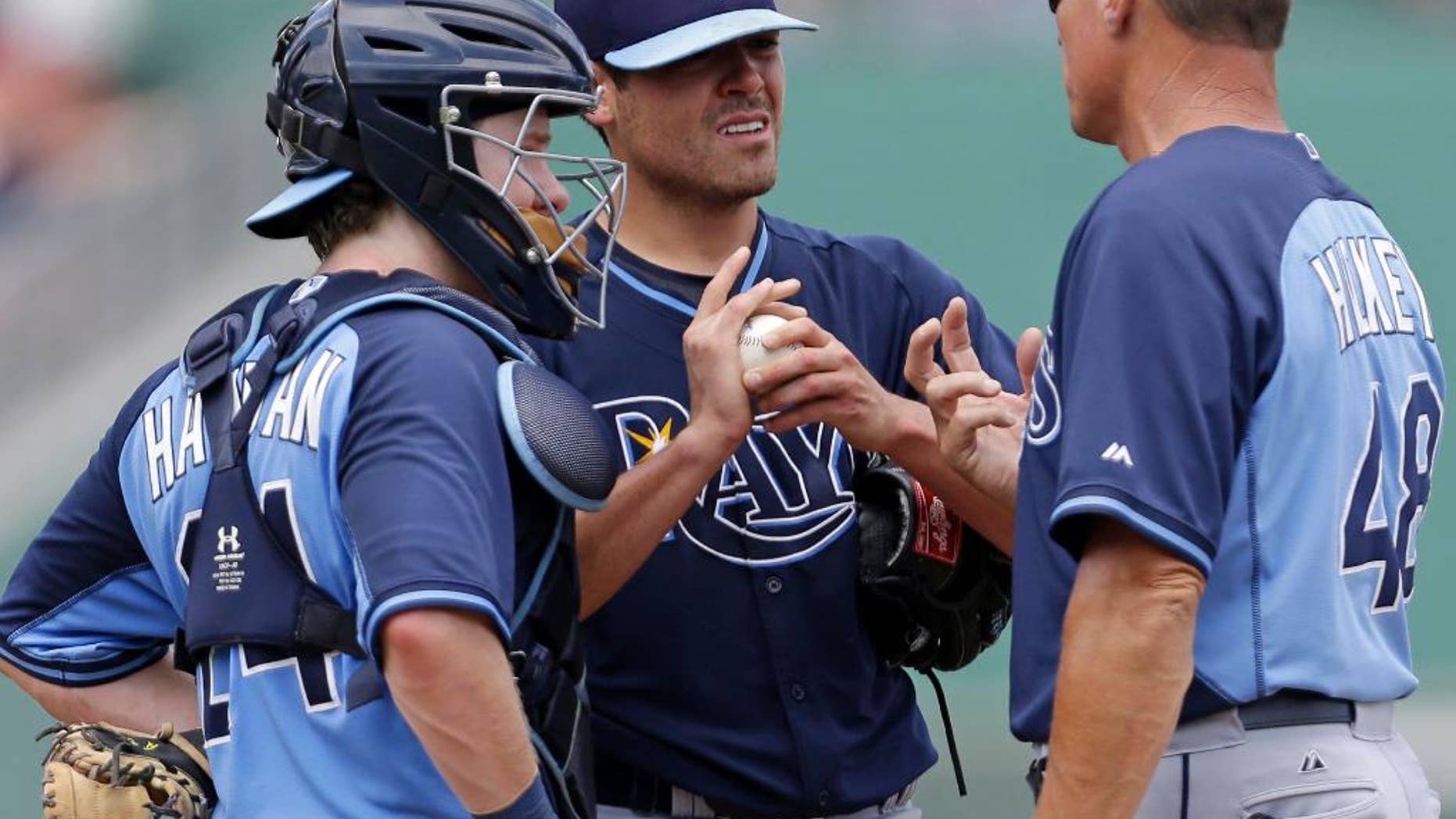 Tampa Bay Rays starting pitcher Matt Moore, center, talks with pitching coach Jim Hickey (48) and catcher Ryan Hanigan (24) in the third inning of an exhibition baseball game against the Boston Red Sox in Fort Myers, Fla., Sunday, March 23, 2014. THe Rays won 9-2. (AP Photo/Gerald Herbert)
