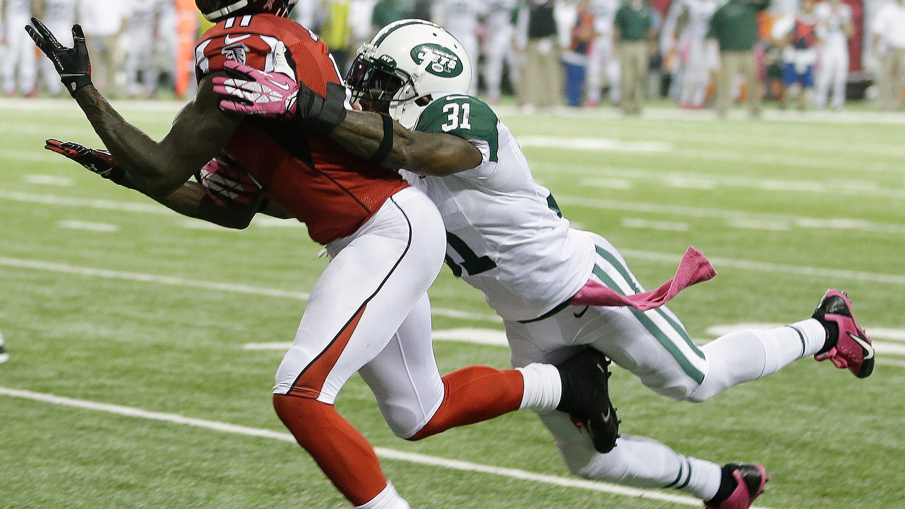 Atlanta Falcons wide receiver Julio Jones (11) misses a catch as New York Jets cornerback Antonio Cromartie (31) defends during the second half of an NFL football game, Monday, Oct. 7, 2013, in Atlanta. (AP Photo/John Bazemore)