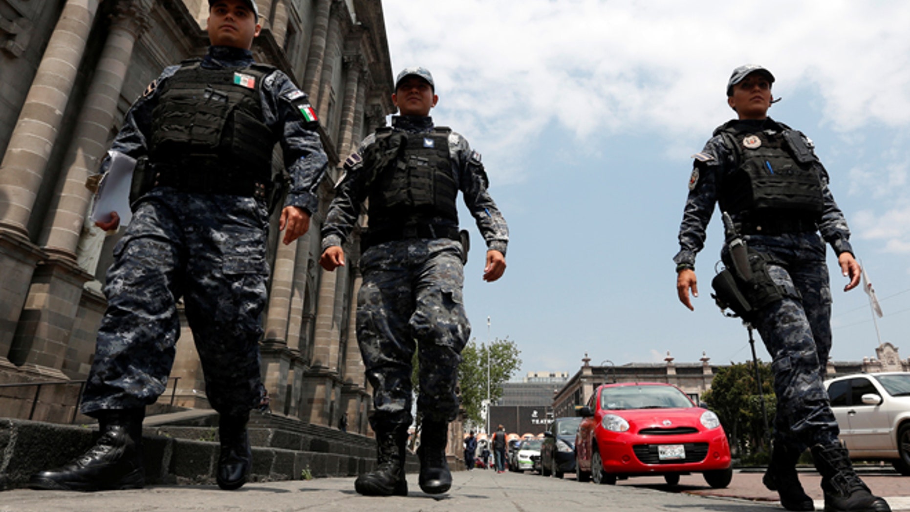FILE: Police officers walk on the main square a day after local election in Toluca, Mexico.