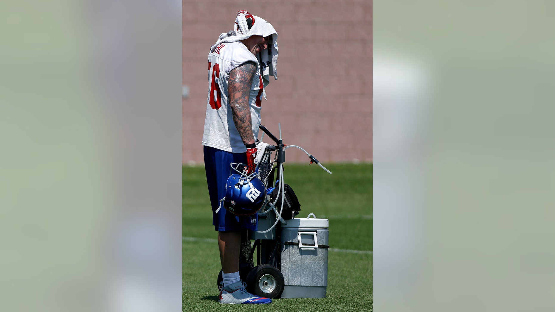 New York Giants' David Diehl wipes his head with a towel during NFL football practice, Thursday, May 30, 2013, in East Rutherford, N.J. (AP Photo/Julio Cortez)