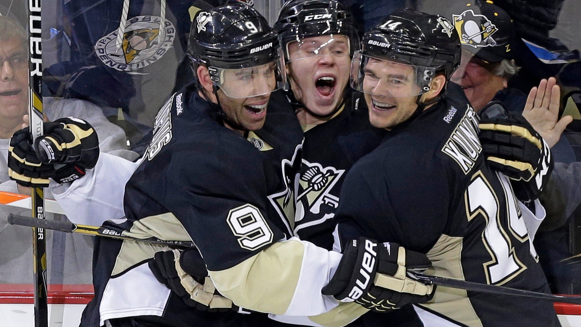 Pittsburgh Penguins' Olli Maatta, center, celebrates his first NHL career goal with teammates Pascal Dupuis (9) and Chris Kunitz (14) in the third period of a NHL hockey game against the Vancouver Canucks in Pittsburgh Saturday, Oct. 19, 2013. The Penguins won in an overtime shootout, 4-3. (AP Photo/Gene J. Puskar)