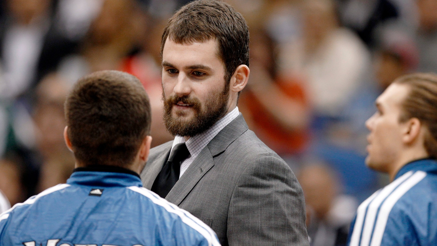 Injured Minnesota Timberwolves forward Kevin Love talks to teammates during a timeout during the first half of an NBA basketball game against the San Antonio Spurs Wednesday, Feb. 6, 2013 in Minneapolis. (AP Photo/Genevieve Ross)