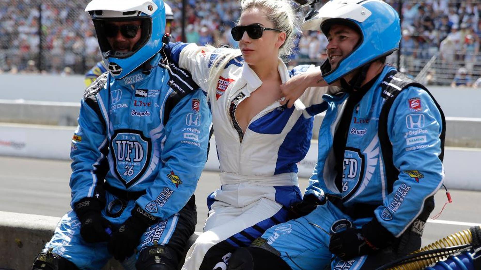 Lady Gaga, center, poses for a photo with members of the Carlos Munoz pit crew during the 100th running of the Indianapolis 500 auto race at Indianapolis Motor Speedway in Indianapolis, Sunday, May 29, 2016. (AP Photo/Jeff Roberson)