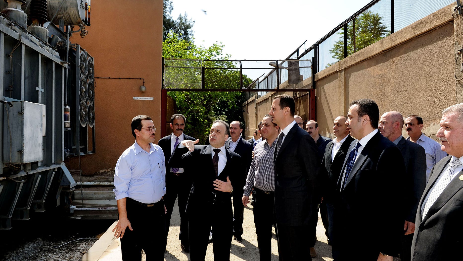 In this photo released by the Syrian official news agency SANA, President Bashar Assad, center, visits the Umayyad Electrical Station on May Day, a day after a powerful bomb hit the capital. in Damascus, Syria, Wednesday, May 1, 2013. (AP Photo/SANA)