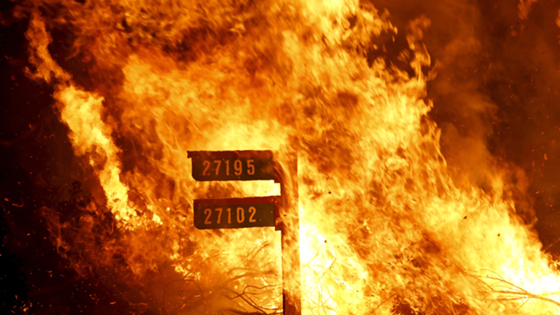 Flames consume a sign containing addresses to homes along Morgan Valley Road in Lake County, California, in this August 12, 2015 file photo. (Photo: REUTERS/Robert Galbraith/Files)