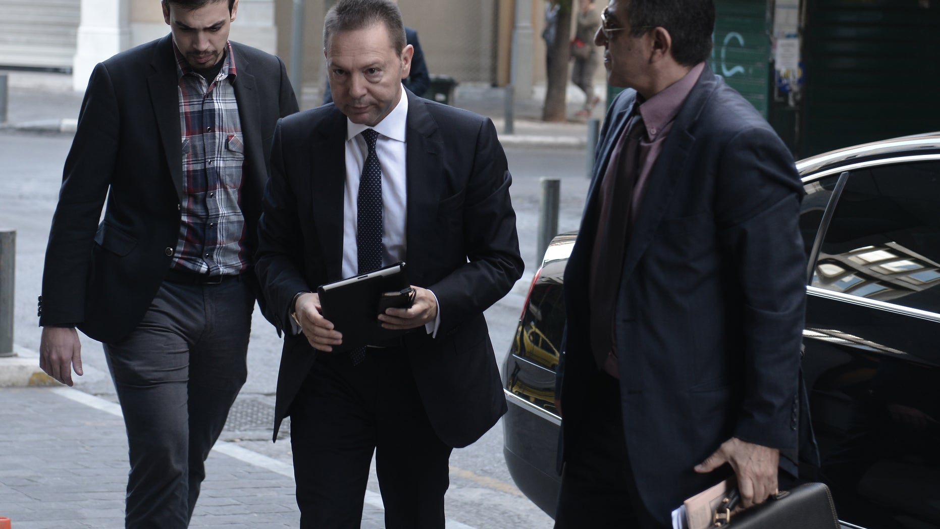 Greek Finance Minister Yiannis Stournaras, center, arrives at the ministry for negotiations with the so-called Troika of Greece's creditors in Athens on Sunday Nov. 10, 2013. Representatives of Greece's creditors started a new round of talks with the government last Tuesday on the conditions for the disbursement of more bailout aid for the debt-ridden country. (AP Photo)