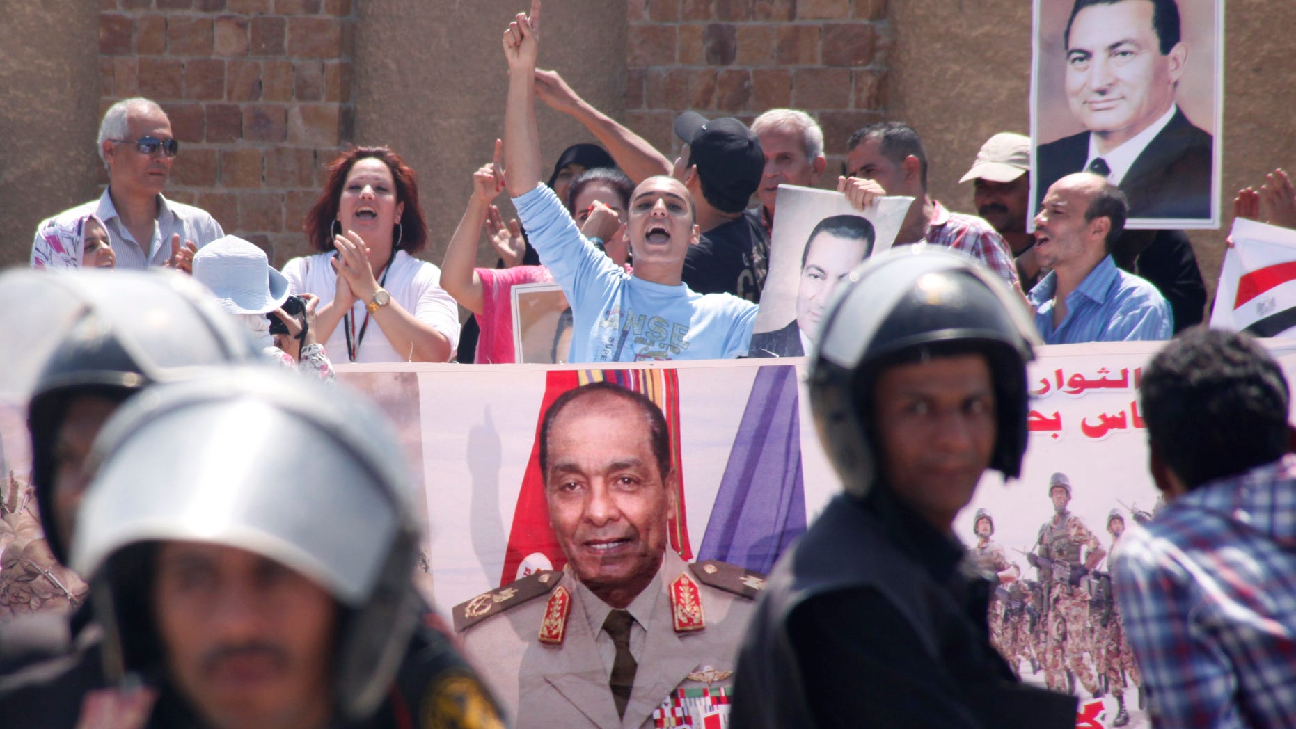 Egyptian pro-Mubarak supporters flash his posters and a giant poster showing field Marshal Mohammed Hussein Tantawi, at center, outside police academy court in Cairo, Egypt, Sunday, Sept.11, 2011 where Mubarak, his two sons Alaa and Gamal, his security chief Habib el-Adly and six top police officers face a session of trial, on charges they ordered the use of lethal force against protesters during Egypt's 18-day uprising killing 850 protesters were killed. Tantawi, Egypt's military ruler Tantawi and one-time confidant of Hosni Mubarak, has failed to attend a court session in which he was expected to offer highly anticipated testimony about the former president's alleged role in the death of protesters.