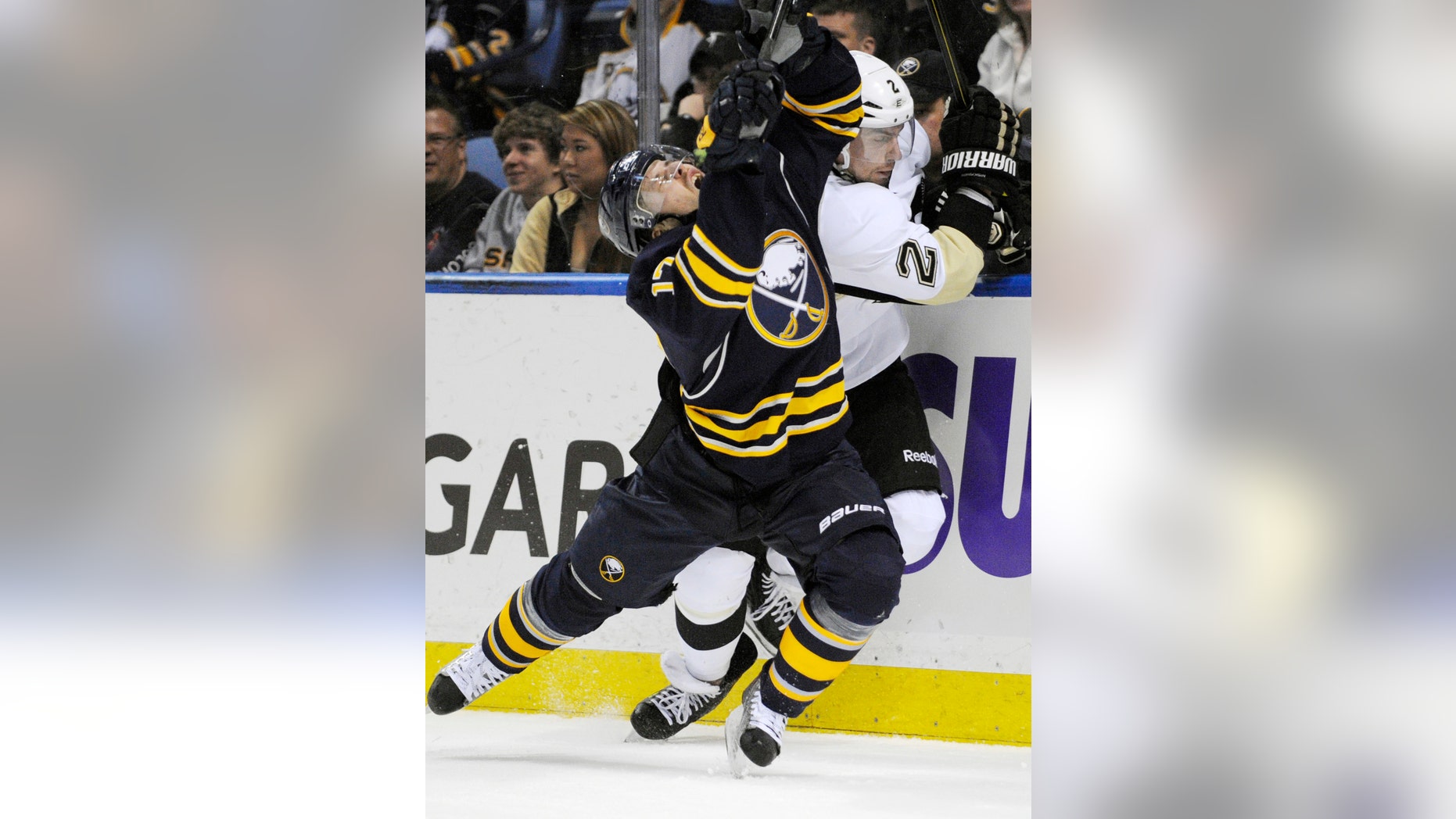 Buffalo Sabres' Linus Omark (17), of Sweden, grimaces after a check on Pittsburgh Penguins' Matt Niskanen (2) during the first period of an NHL hockey game in Buffalo, N.Y., Wednesday, Feb. 5, 2014. Pittsburg won 5-1. (AP Photo/Gary Wiepert)