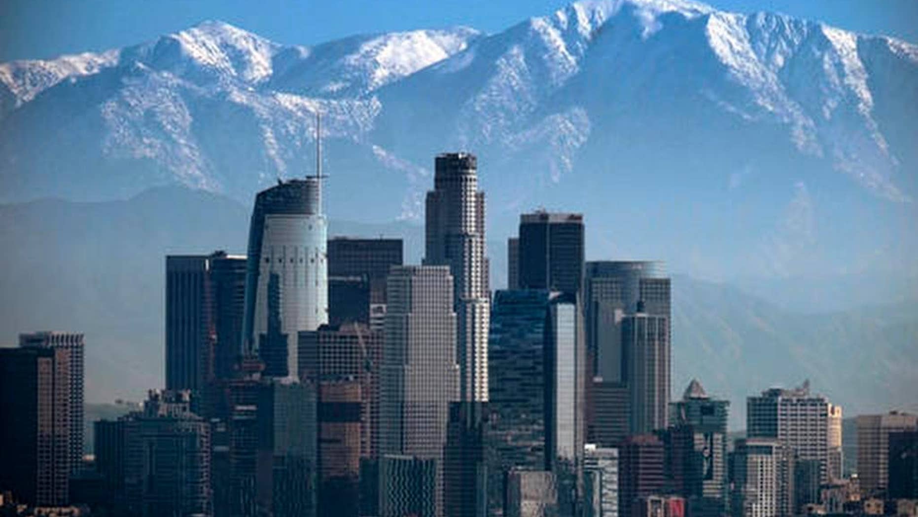 FILE - This Jan. 25, 2017 file photo shows a snow covered Mount Baldy, the highest peak among the San Gabriel Mountains behind downtown Los Angeles. Searchers have found the body of a veteran hiker who vanished while climbing the 10,000-foot (3,000-meter) mountain just northeast of Los Angeles. Seuk "Sam" Kim, had hiked to the top of Mount Baldy in the San Gabriel Mountains more than 700 times before he went missing last week. (AP Photo/Richard Vogel, File)