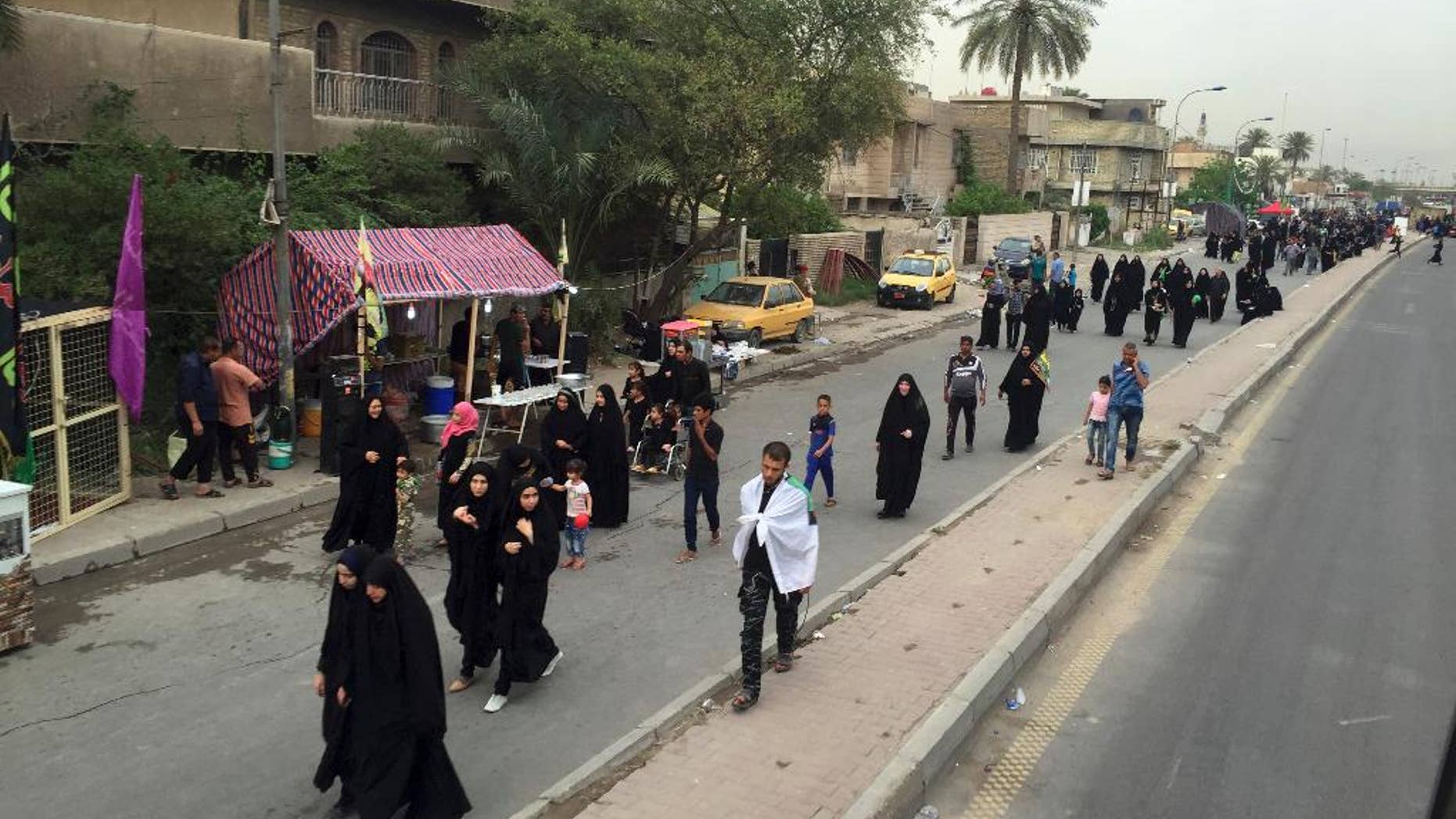 Shiite pilgrims march toward the Imam Mousa al-Kadhim shrine to commemorate the anniversary of the Imam's death in Baghdad, Iraq, Friday, April 29, 2016. The anniversary of the 8th-century Imam's death draws tens of thousands of Shiites from all walks to converge on his golden-domed shrine in northern Baghdad. The pilgrims typically march to the shrine while hundreds of tents are erected to offer them free food, drinks and services. (AP Photo/Ali Abdul Hassan)