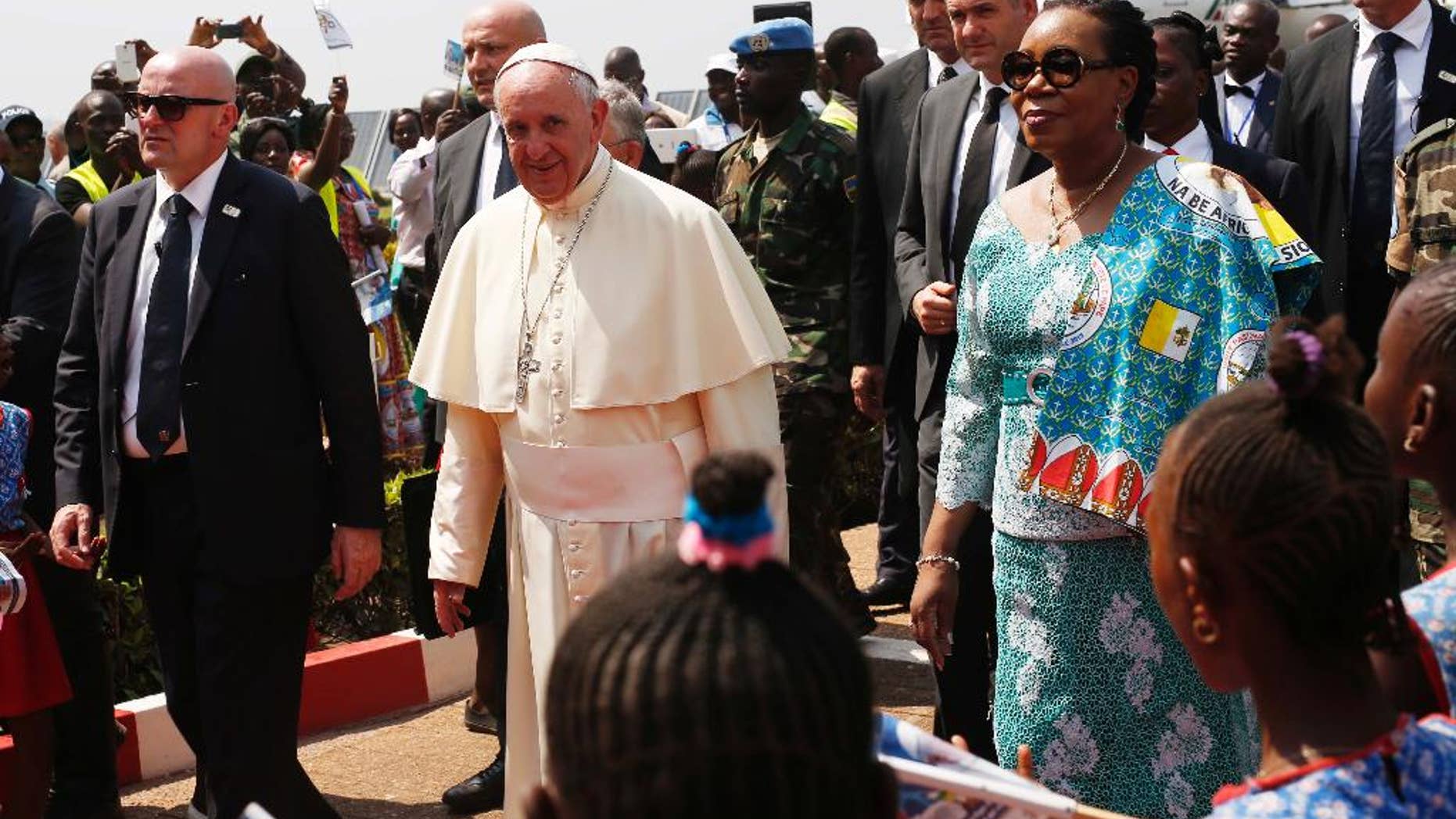 FILE- In this Sunday Nov. 29, 2015 file photo, Pope Francis arrives in Bangui, Central African Republic, on the third leg of his trip to Africa. Heavy gunfire, a grenade and threats of violence in Central African Republic on Sunday Dec.13, 2015, prevented some residents from participating in a constitutional referendum aimed at moving the country out of a transition and toward stability. The vote on a new constitution adopted by the transitional government comes nearly two weeks after a visit by Pope Francis, who called for peace and Muslim-Christian reconciliation. (AP Photo/Jerome Delay, File)
