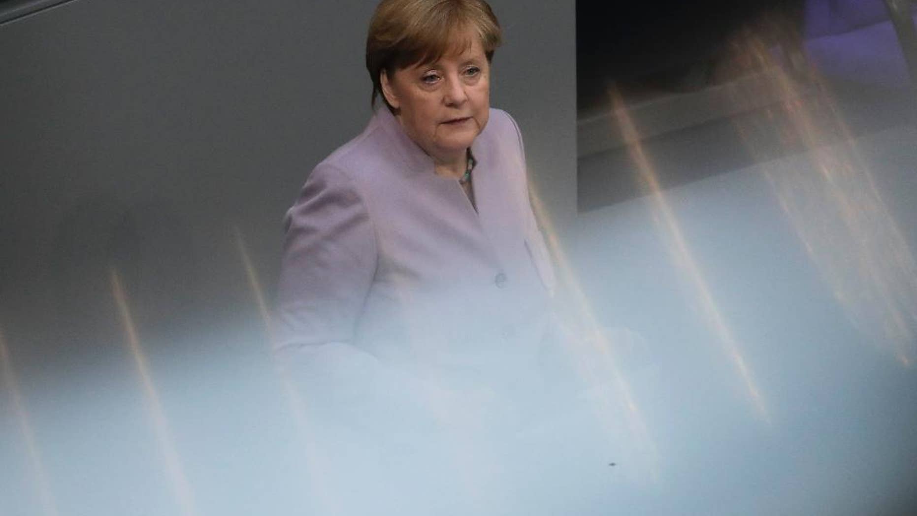 In this photo taken with reflections of a hand rail at the visitors tribune, German Chancellor Angela Merkel delivers her speech about the European Union at the German parliament Bundestag in Berlin, Thursday, April 27, 2017. (AP Photo/Markus Schreiber)