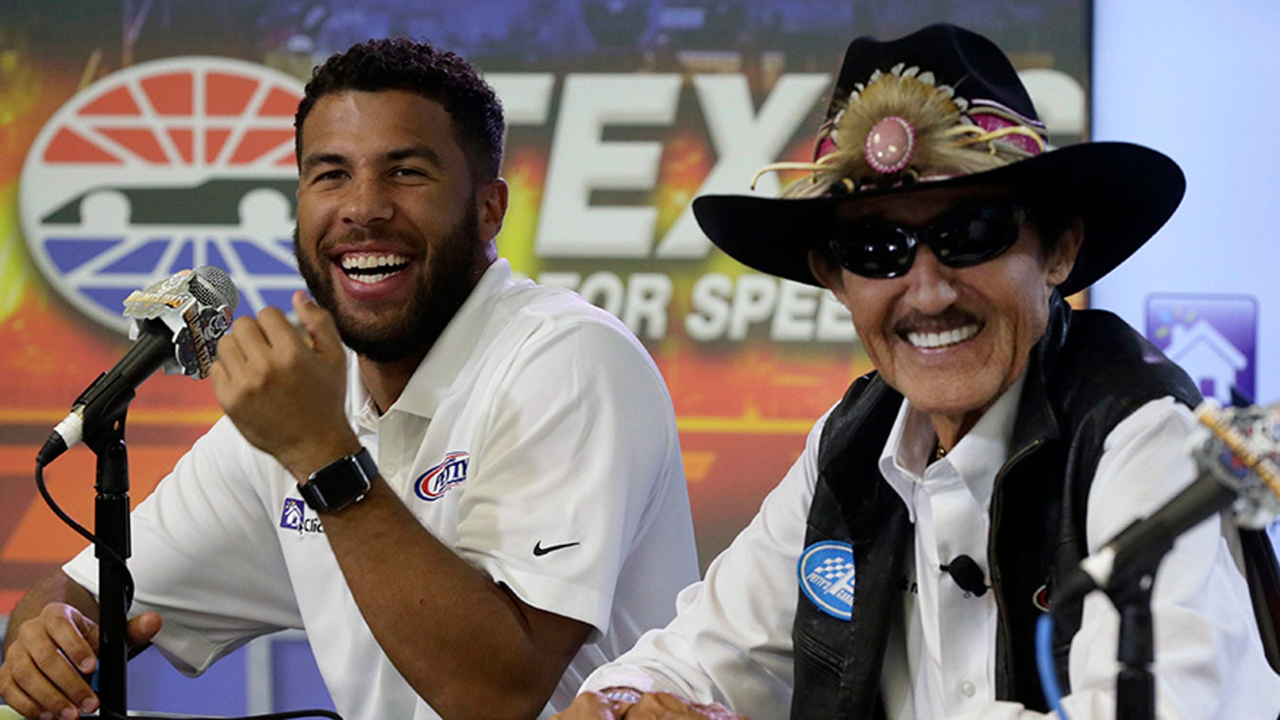 Darrell Wallace Jr., left, laughs with Richard Petty during news conference before NASCAR Cup series auto race qualifying at Texas Motor Speedway in Fort Worth, Texas, Friday, Nov. 3, 2017. Richard Petty Motorsports announced that Wallace Jr. will drive the No. 43 car for the organization beginning in 2018. (AP Photo/LM Otero)