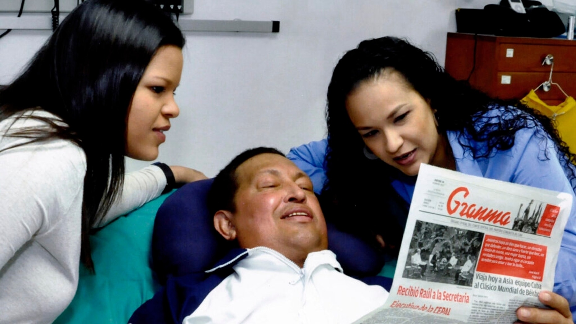 In this photo released Friday, Feb. 15, 2013 by Miraflores Presidential Press Office, Venezuela's President Hugo Chavez, center, poses for a photo with his daughters, Maria Gabriela, left, and Rosa Virginia as he holds a copy of Cuba's state newspaper at an unknown location in Havana, Cuba, Thursday, Feb. 14, 2013. Chavez remains in Havana undergoing unspecified treatments following his fourth cancer-related operation on Dec. 11. He has hasn't been seen or spoken publicly in more than two months. (AP Photo/Miraflores Presidential Press Office)