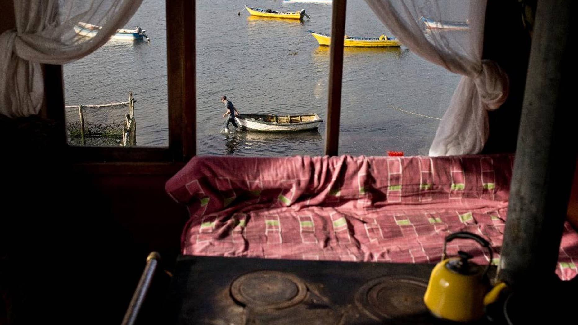 In this May 10, 2016, Marco, the 19-year-old son of fisherwoman Marisol Millaquien prepares to take out a boat on an expedition, in hopes of providing food for the dinner table, in Quetalmahue, on Chile's Chiloe Island, during the country's worst ever "red tide" environmental disaster. The view from Millaquien's stilt home is desolate: dozens of abandoned ghostly boats, dead birds and shellfish. "I'm 46. I've seen red tide before, but never like this," she said. (AP Photo/Esteban Felix)