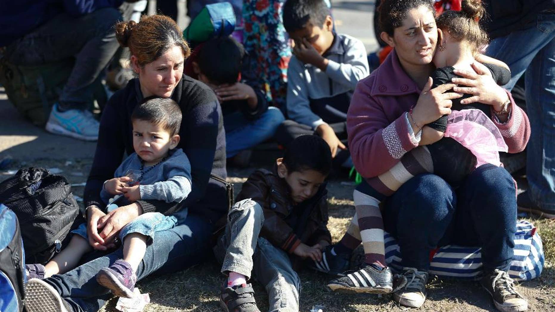 FILE - In this Sept. 9. 2015 file photo a group of migrants rest near the Hungarian border with Serbia, in Roszke, southern Hungary. A spokesman for Hungary's governing Fidesz party says Wednesday March 8, 2017 its lawmakers will likely submit a new law regulating nongovernmental organizations within two weeks. Fidesz spokesman Janos Halasz says the law is aimed at revealing the foreign funding received by "agent organizations" seeking to influence Hungarian politics. (AP Photo/Matthias Schrader, file)