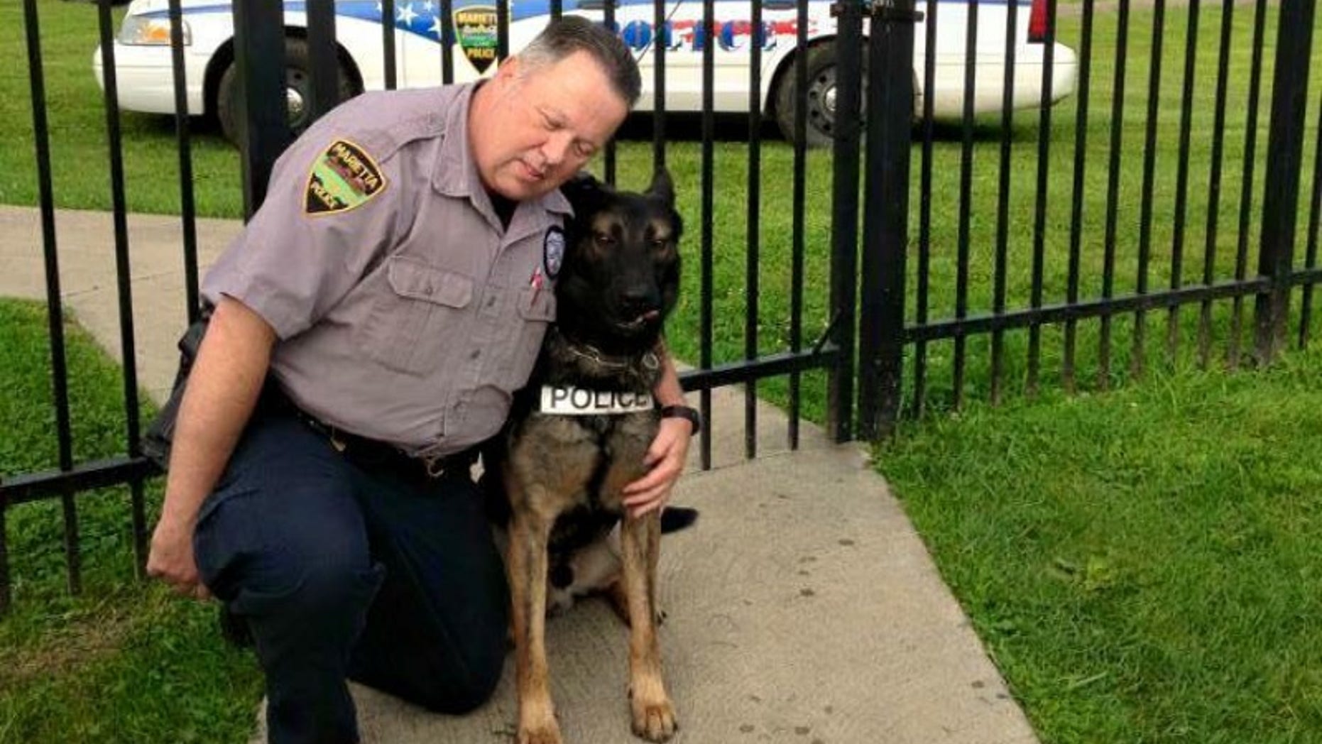 Matthew Hickey puts his arms around K-9 partner Ajax.