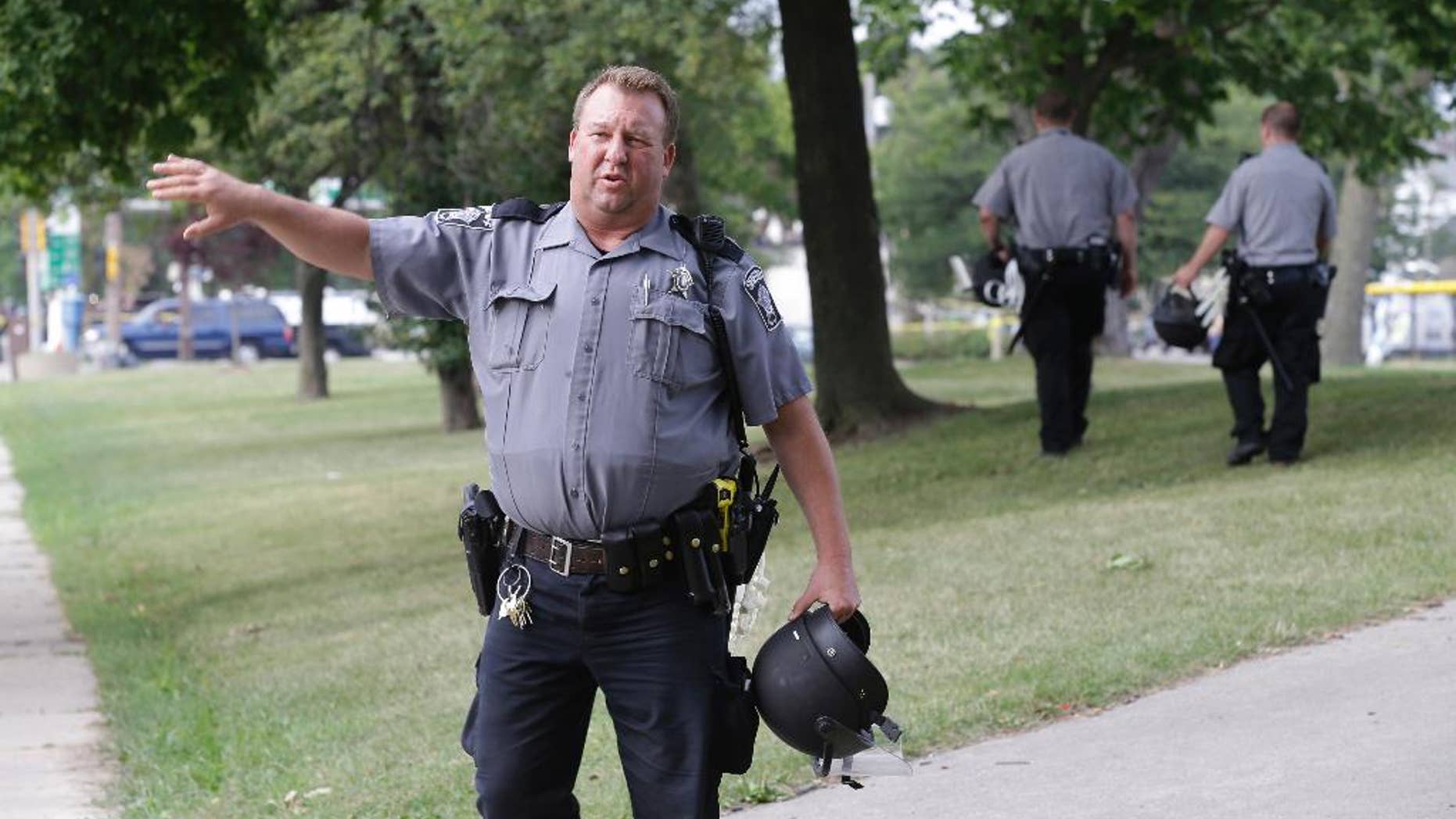 Police prepare to close a park in Milwaukee, Monday, Aug. 15, 2016. Following a night of violence that left half a dozen businesses in flames, the Milwaukee police chief expressed surprise at the level of unrest that erupted after the fatal shooting of a black man by a black officer. "This was, quite frankly, unanticipated," Chief Edward Flynn said Monday, two days after the worst of the rioting hit the Sherman Park neighborhood on the city's economically depressed and largely black north side. (AP Photo/Jeffrey Phelps)