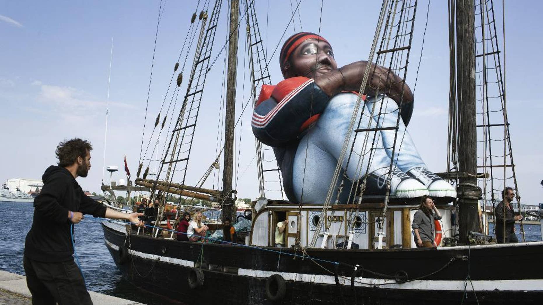The artwork "Inflatable Refugee" by Belgian artist collective Shellekens and Peleman on the deck of a wooden boat arrives in Copenhagen, Monday May 23, 2016. The creators say the artwork is a “symbol of the dehumanization of the refugee and the current refugee crisis happening in the world.” (Mathias Svold Maagaard/Polfoto via AP) DENMARK OUT