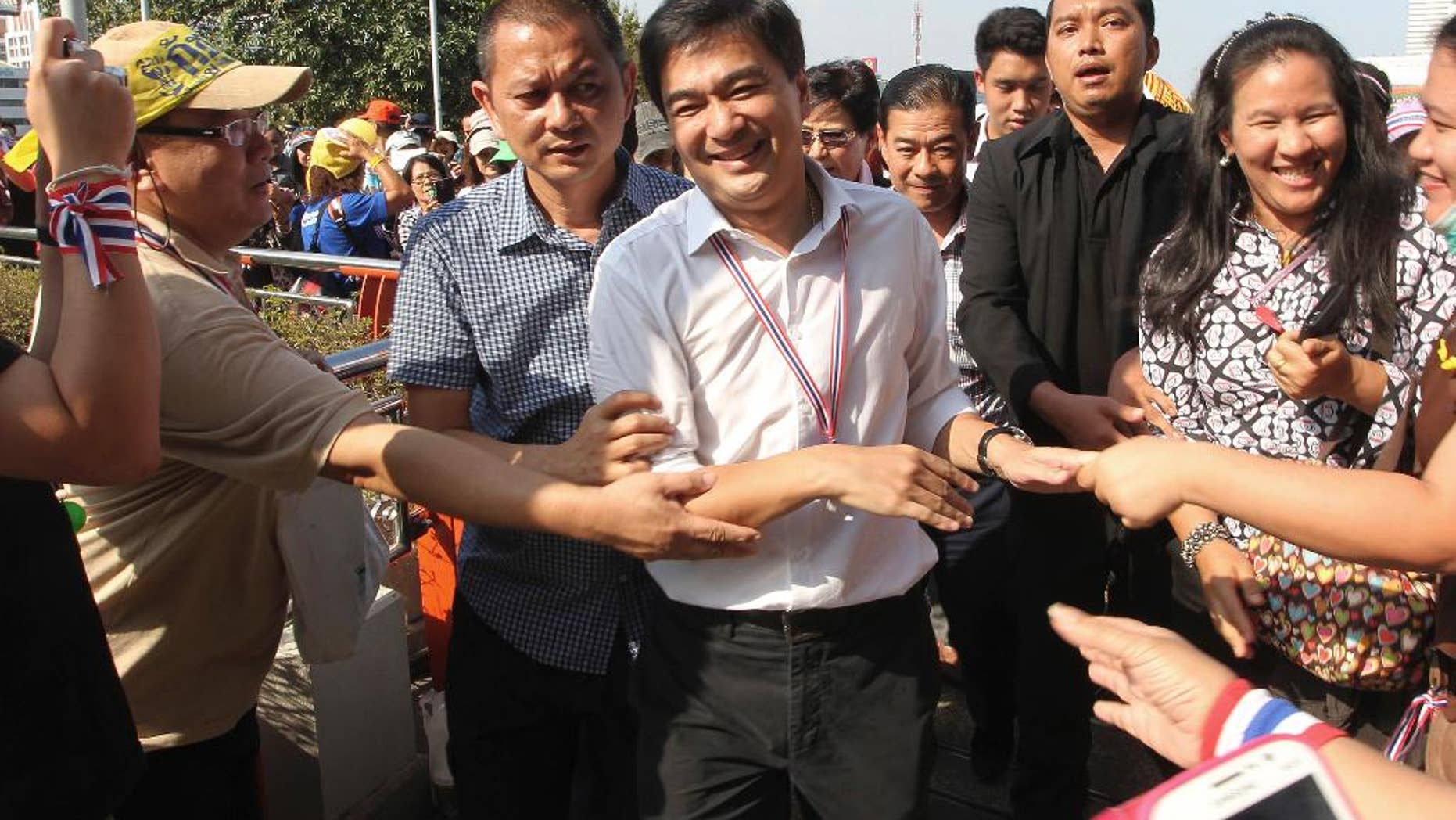 FILE- In this Monday, Jan. 13, 2014, file photo, former Thailand Prime Minister Abhisit Vejjajiva, center, is greeted by supporters as he appears at an overfly near Victory Monument where anti-government protesters gather for a rally in Bangkok, Thailand. Former Prime Minister Abhisit Vejjaviva on Wednesday, July 27, 2016, joined a growing chorus of voices opposed to a new constitution proposed by the military government. (AP Photo/Apichart Weerawong, File)