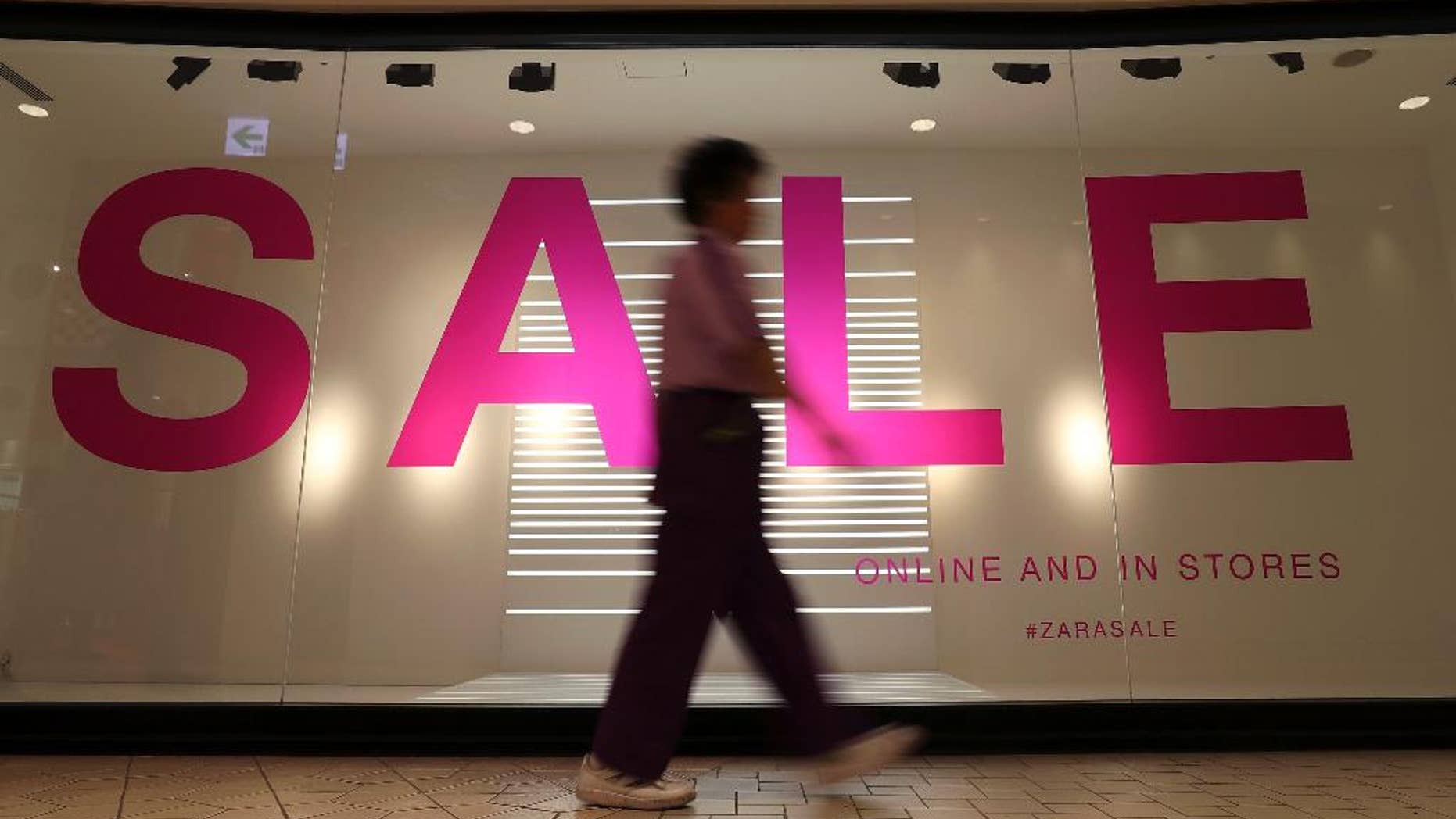 In this Feb. 20, 2017 photo, a woman walks in front of the window of a boutique in Tokyo. Japan has reported that its inflation and jobless rates were little changed in January and consumer spending was lackluster. The economic data released Friday, March 3 show the world's No. 3 economy coasting along with only slight improvements despite recent stronger exports and manufacturing output. (AP Photo/Shizuo Kambayashi)