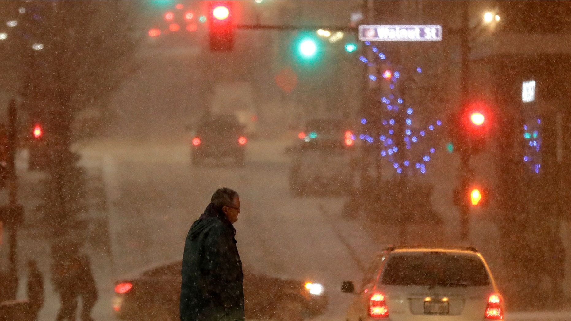 A pedestrian walks across a street in downtown Kansas City, Mo., on Saturday, Dec. 17, 2016.