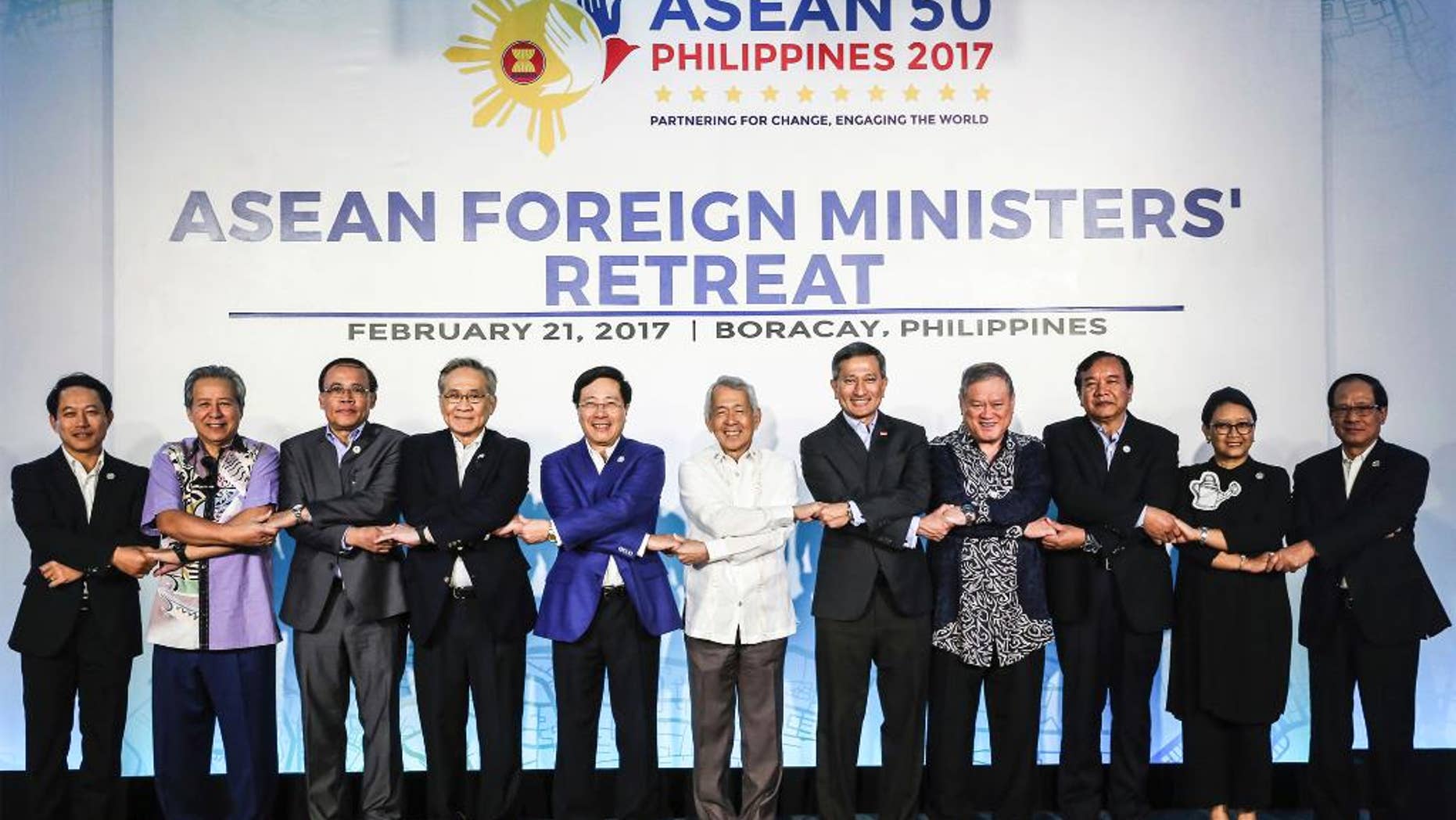 In this photo provided by Presidential Communications Operations Office ASEAN, Foreign ministers from the Association of South East Asian Nations (ASEAN) link arms during the ASEAN Foreign Ministers' Retreat in Boracay, Aklan province, central Philippines, Tuesday, Feb. 21, 2017. From left, Laos' Foreign Minister Saleumxay Kommasith, Malaysia's Foreign Minister AnifH Aman, Myanmar's Minister of State for Foreign Affairs U Kyaw Tin, Thailand's Foreign Minister Don Pramudwinai, Vietnam's Foreign Minister Pham Binh Minh, AMM Retreat Chair and Philippine Secretary of Foreign Affairs Perfecto Yasay, Singapore's Foreign Minister Vivian Balakrishnan, Brunei Darussalam's Minister at the Prime Minister's Office and Second Minister of Foreign Affairs and Trade Pehin Dato' Lim Jock Seng, Cambodia's Senior Minister and Minister for MFAIC Prak Sokhonn, Indonesia's Foreign Minister Retno Marsudi, and ASEAN Secretary-General, ASEAN Secretariat Le Luong Minh. (Presidential Communications Operations Office ASEAN via AP)