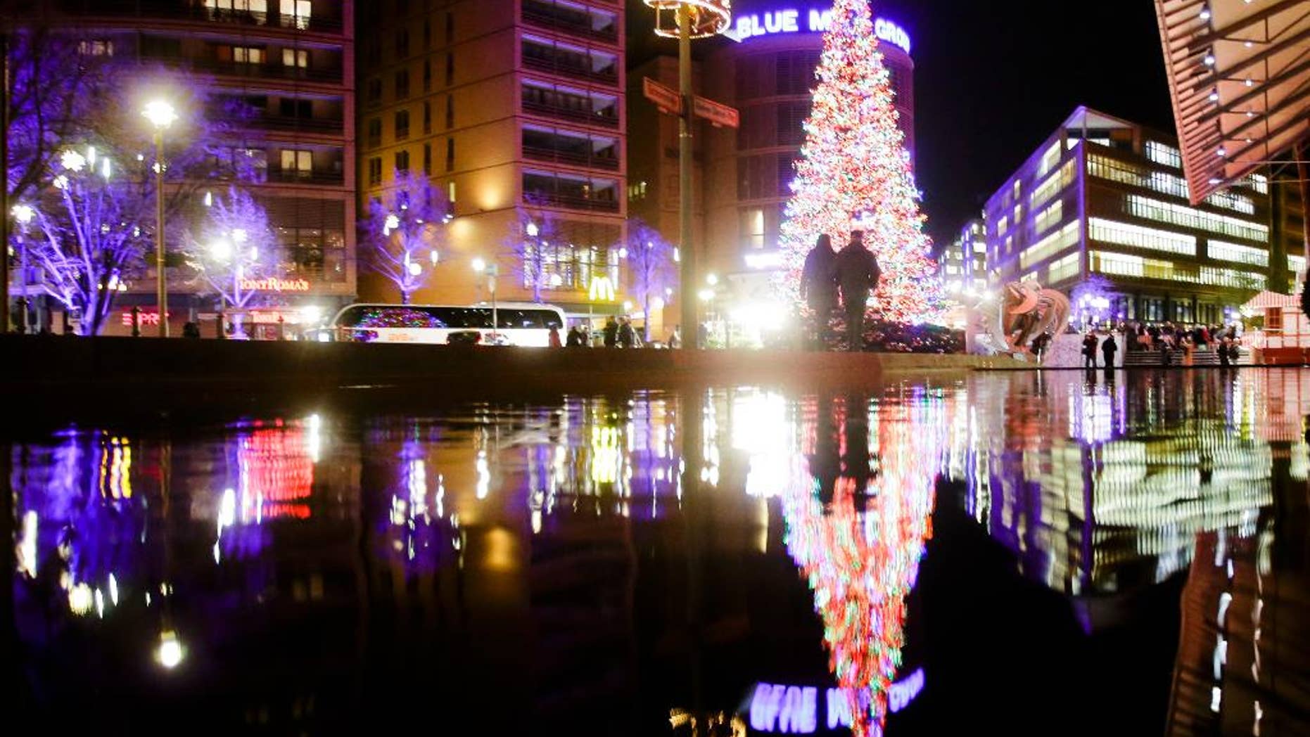 Visitors walk in front of the illuminated Christmas tree near the Christmas market at the Potsdamer Platz square in Berlin, Germany, Thursday, Dec. 8, 2016. (AP Photo/Markus Schreiber)