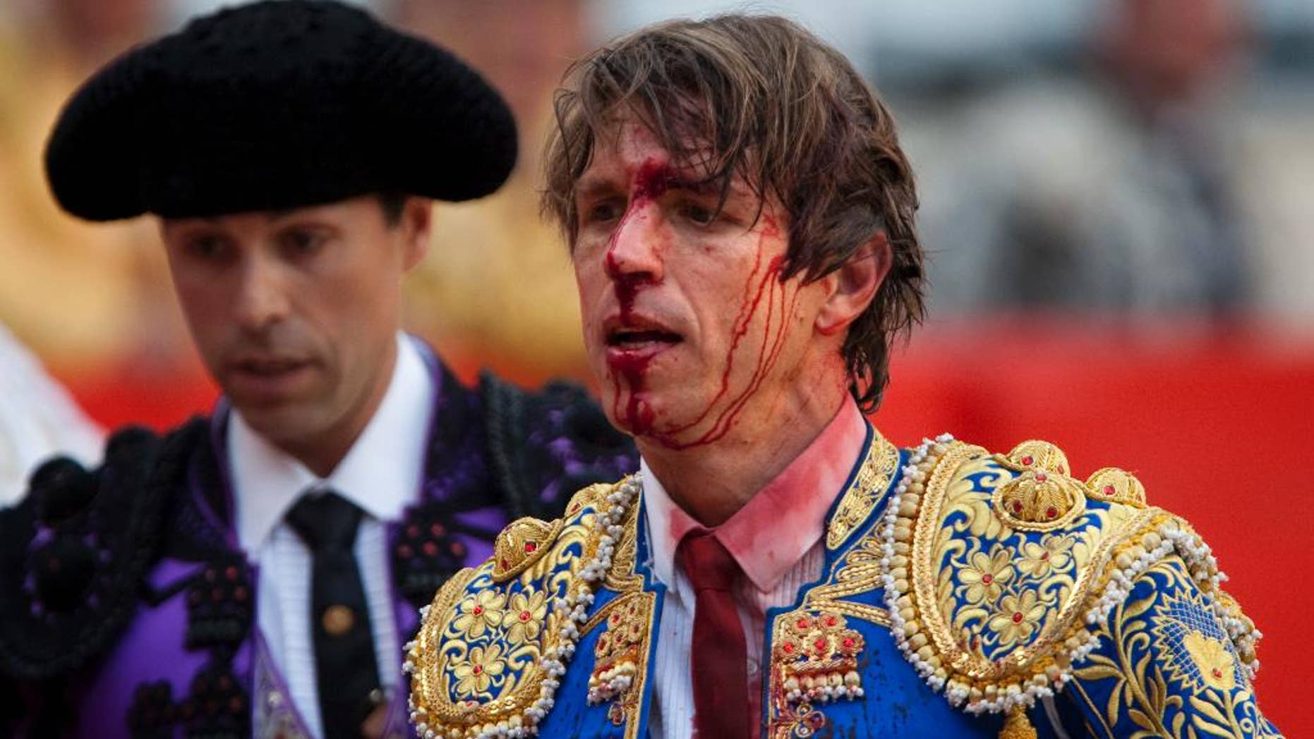 FILE - In this April 25, 2010 file photo, bullfighter Manuel Diaz "El Cordobes", right, reacts after being gored by a bull during a bullfight at the Monumental Bullring in Barcelona, Spain. The southern Cordoba city court has held a hearing into a decades-old paternity dispute over whether two of Spain's most well-known bullfighters and who share the same showname, 'El Cordobes', are really father and son. The court began studying the claim Thursday April 28, 2016 by Manuel Diaz, 47 that he is the son of retired bullfighting legend Manuel Benitez, 79, something the elder torero has never recognized. (AP Photo/Emilio Morenatti, File)