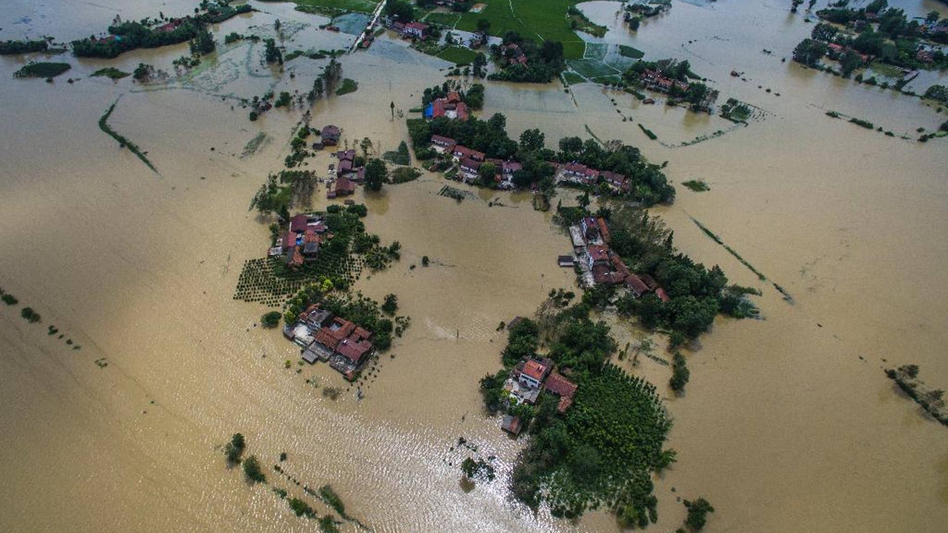 This Wednesday, July, 20, 2016 photo released by Xinhua News Agency, shows village houses and field partially submerged by flood waters in Gaoyang Town, Shayang County, central China's Hubei Province. China says dozens of people have died or gone missing since Monday in massive floods across the country's north. (Xiao Yijiu/Xinhua via AP)