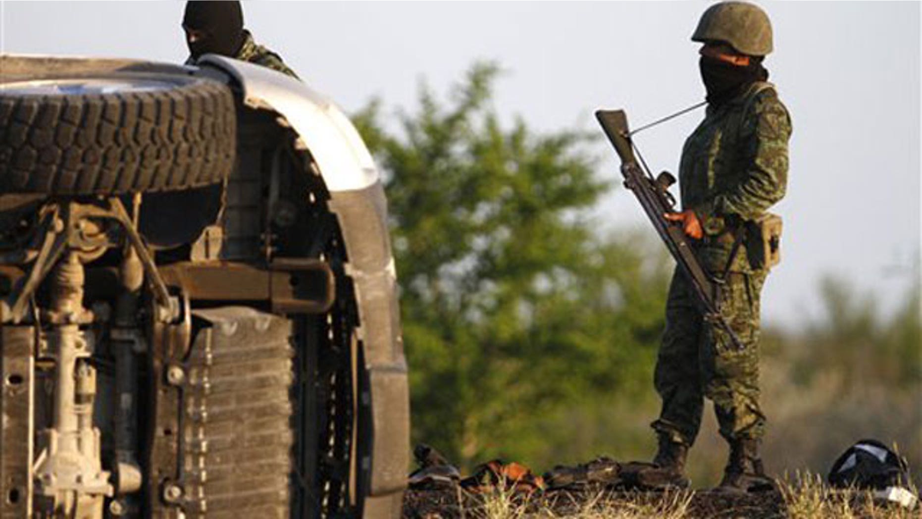 March 30: Soldiers stand by an overturned vehicle after a shootout on the outskirts of Monterrey, Mexico.