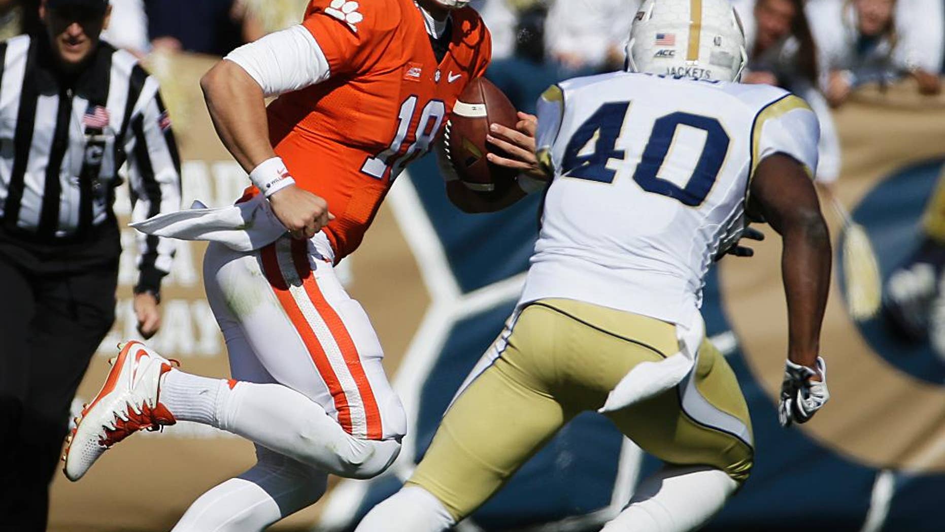 Clemson quarterback Cole Stoudt, left, is chased while running the ball by Georgia Tech's Paul Davis in the second quarter of an NCAA college football game, Saturday, Nov. 15, 2014, in Atlanta. Georgia Tech won 28-6. (AP Photo/David Goldman)