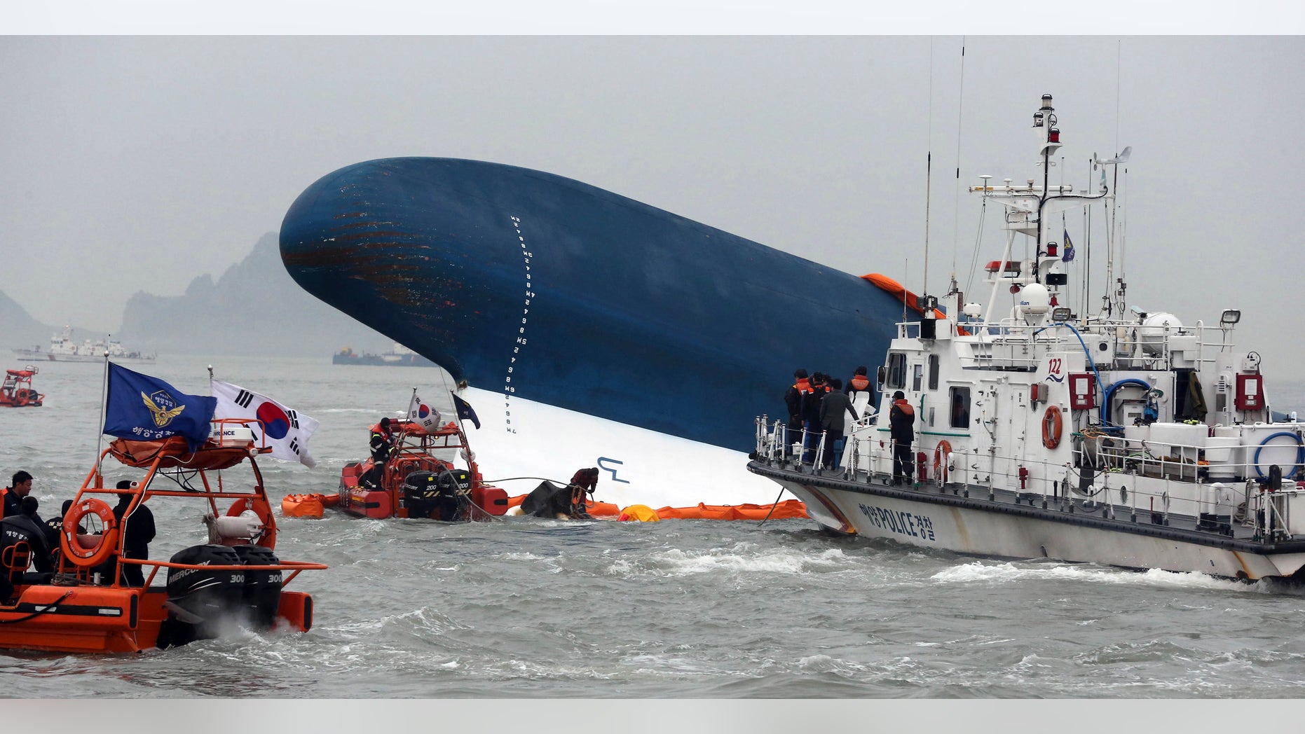 South Korean Coast Guard officers try to rescue missing passengers from a sunken ferry in the water off the southern coast near Jindo, south of Seoul, South Korea, Thursday, April 17, 2014. Fears rose Thursday for the fate of more than 280 passengers still missing more than 24 hours after their ferry flipped onto its side and filled with water off the southern coast of South Korea. (AP Photo/Yonhap) KOREA OUT