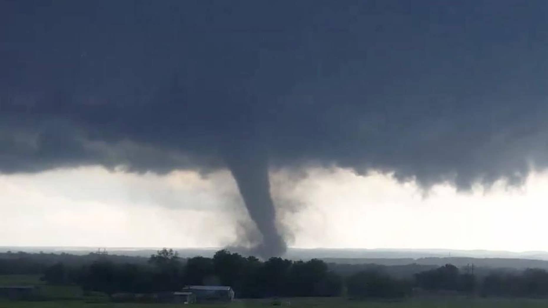 This image made from a video taken through a car window shows a tornado near Wynnewood, Okla., Monday, May 9, 2016. A broad tornado capable of leaving "catastrophic" damage in its wake churned across the Oklahoma landscape Monday, prompting forecasters to declare a tornado emergency for two communities directly in its path. (Hayden Mahan via AP) MANDATORY CREDIT