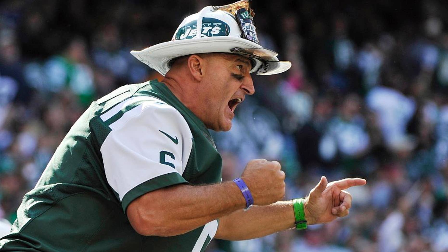 FILE - In this Oct. 14, 2012, file photo, New York Jets fan Ed Anzalone cheers during the first half of an NFL football game against the Indianapolis Colts in East Rutherford, N.J. Anzalone never wanted to hang up his helmet. The New York Jets super-fan known as Fireman Ed simply grew tired of the increasing harassment in the stands at MetLife Stadium. (AP Photo/Bill Kostroun, File)