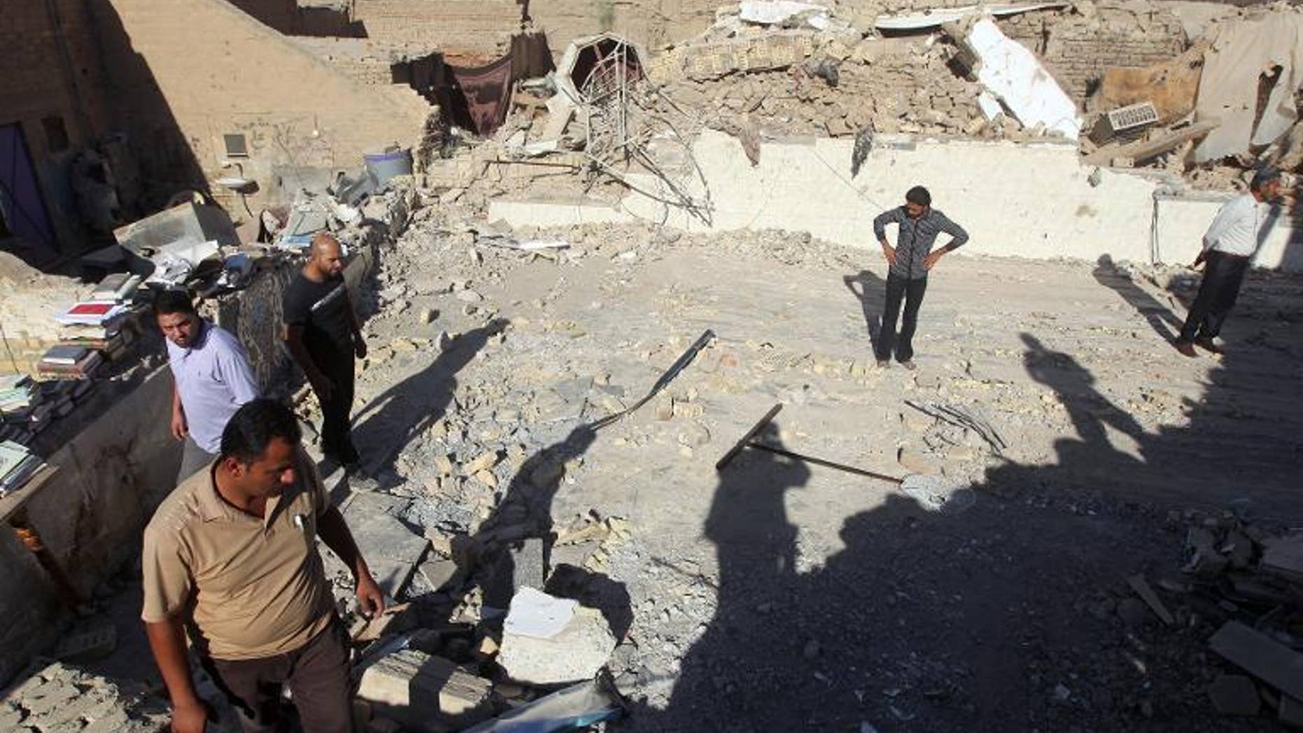 Iraqis inspect the scene following an explosion at the Al-Hussein mosque south of Baghdad, on September 30, 2013